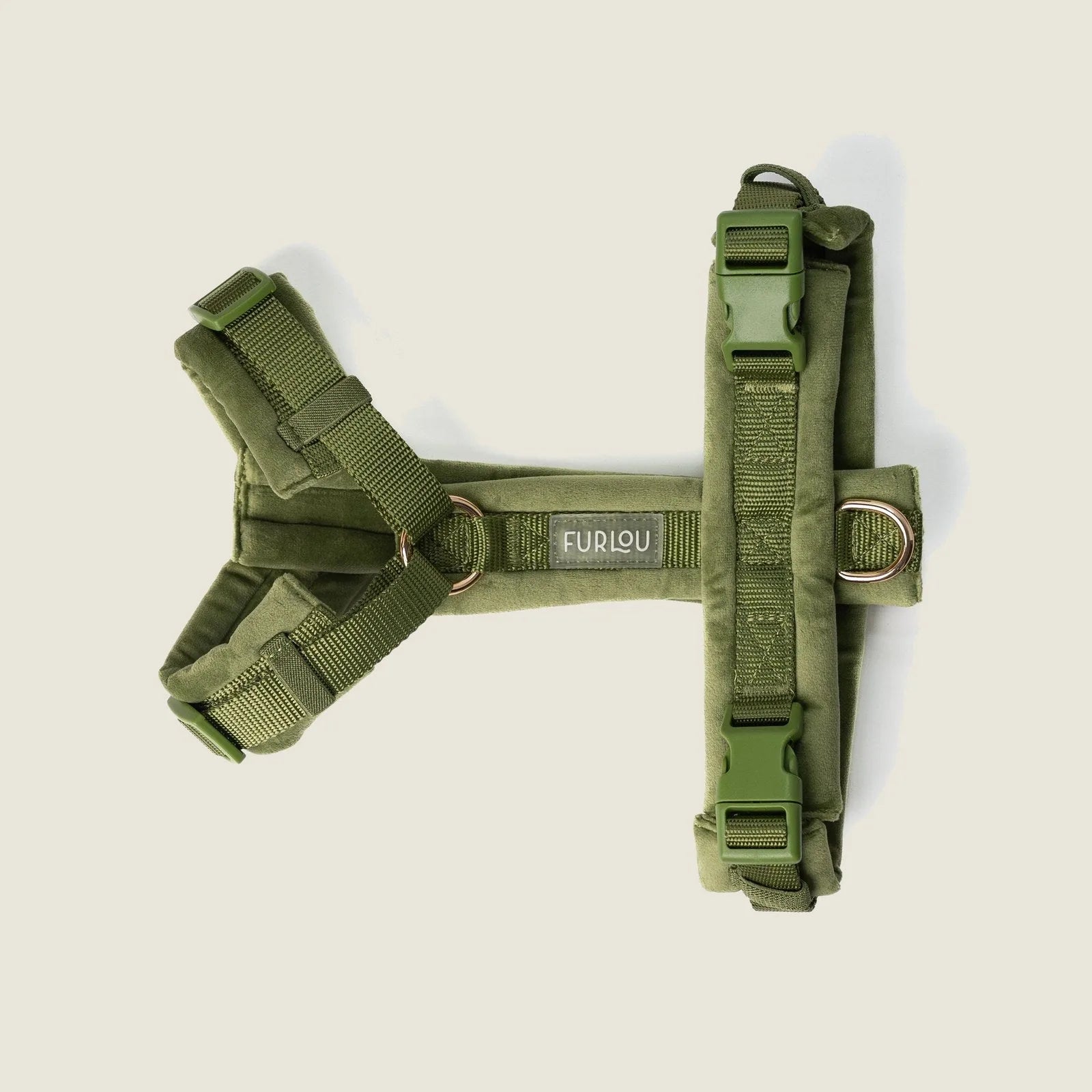Green velvet dog harness with adjustable straps and gold hardware, featuring a plush design for comfort and style.