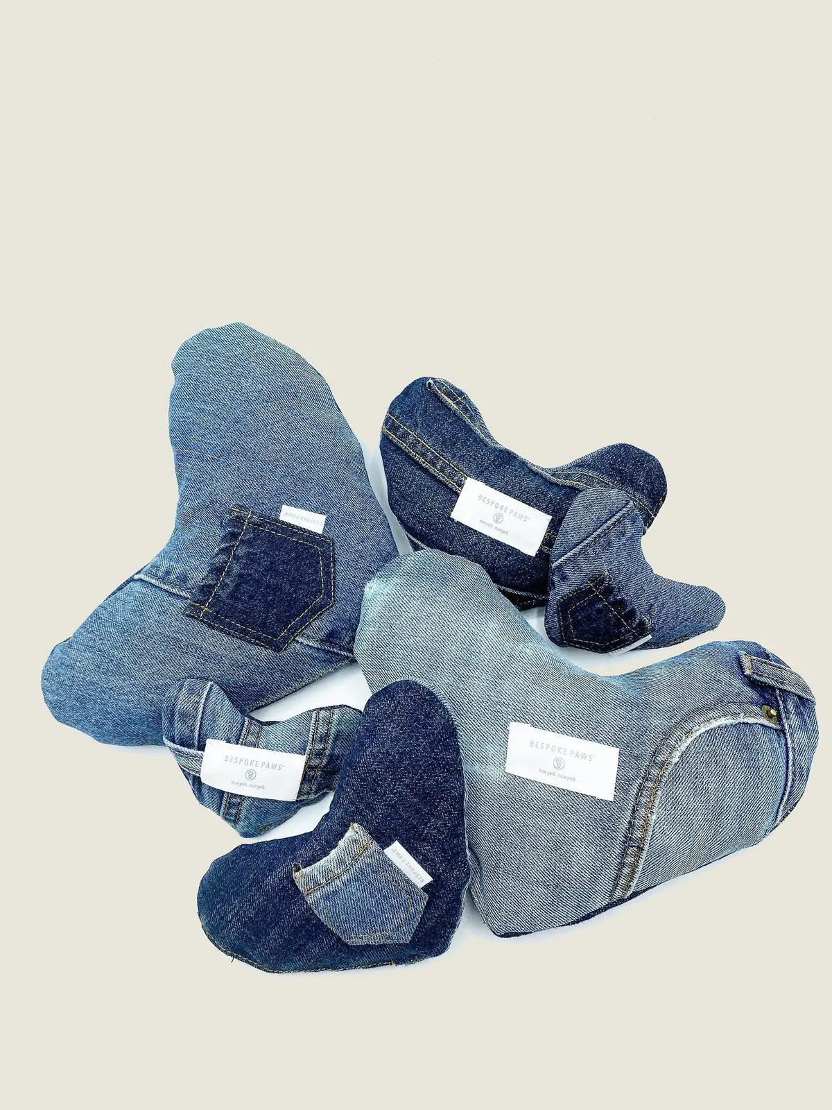 Plush heart-shaped dog toys made from upcycled denim, featuring unique pockets and multiple shades of blue.