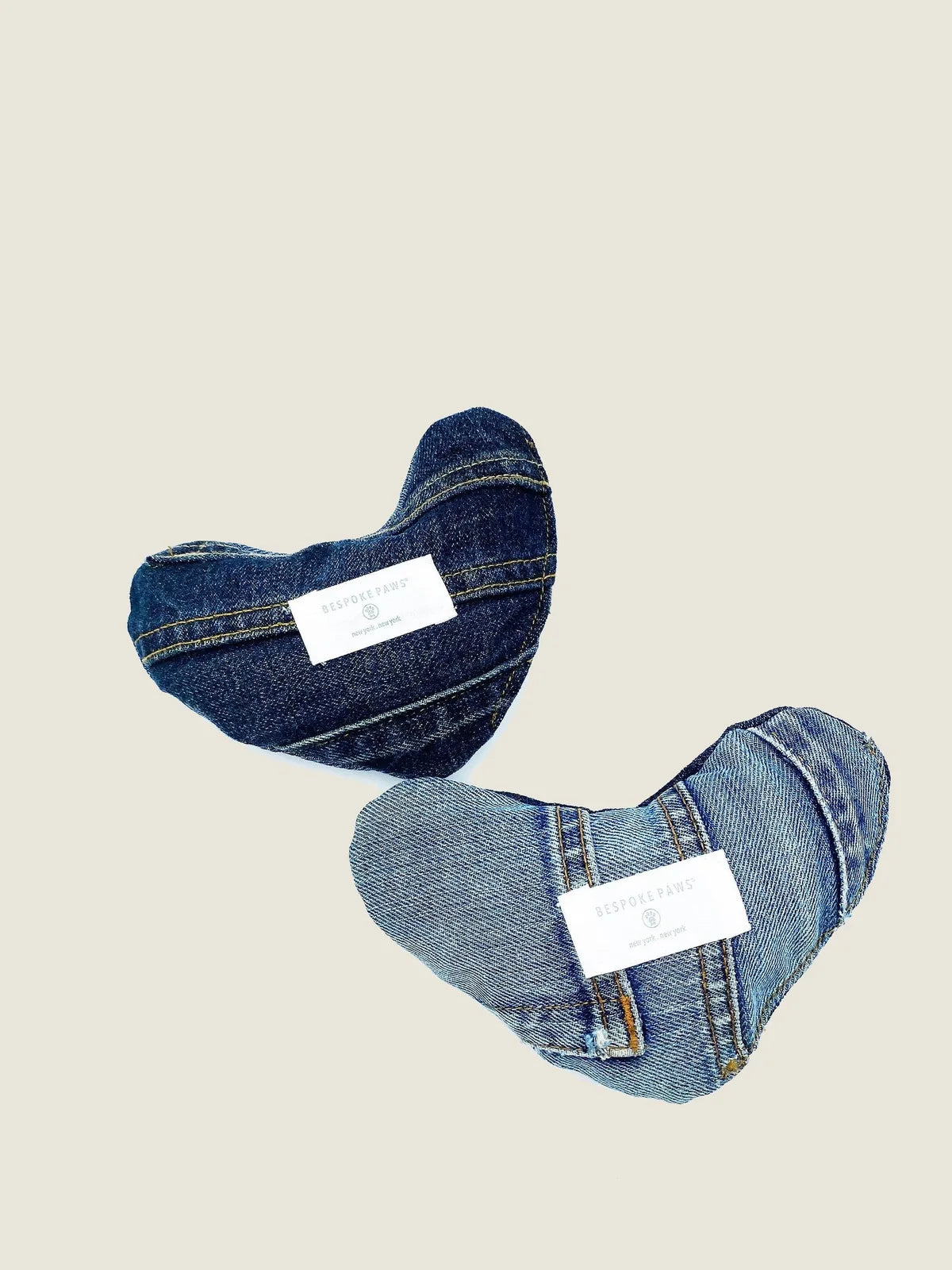 Plush heart-shaped dog toys made from upcycled denim, featuring unique designs and BESPOKE PAWS branding.