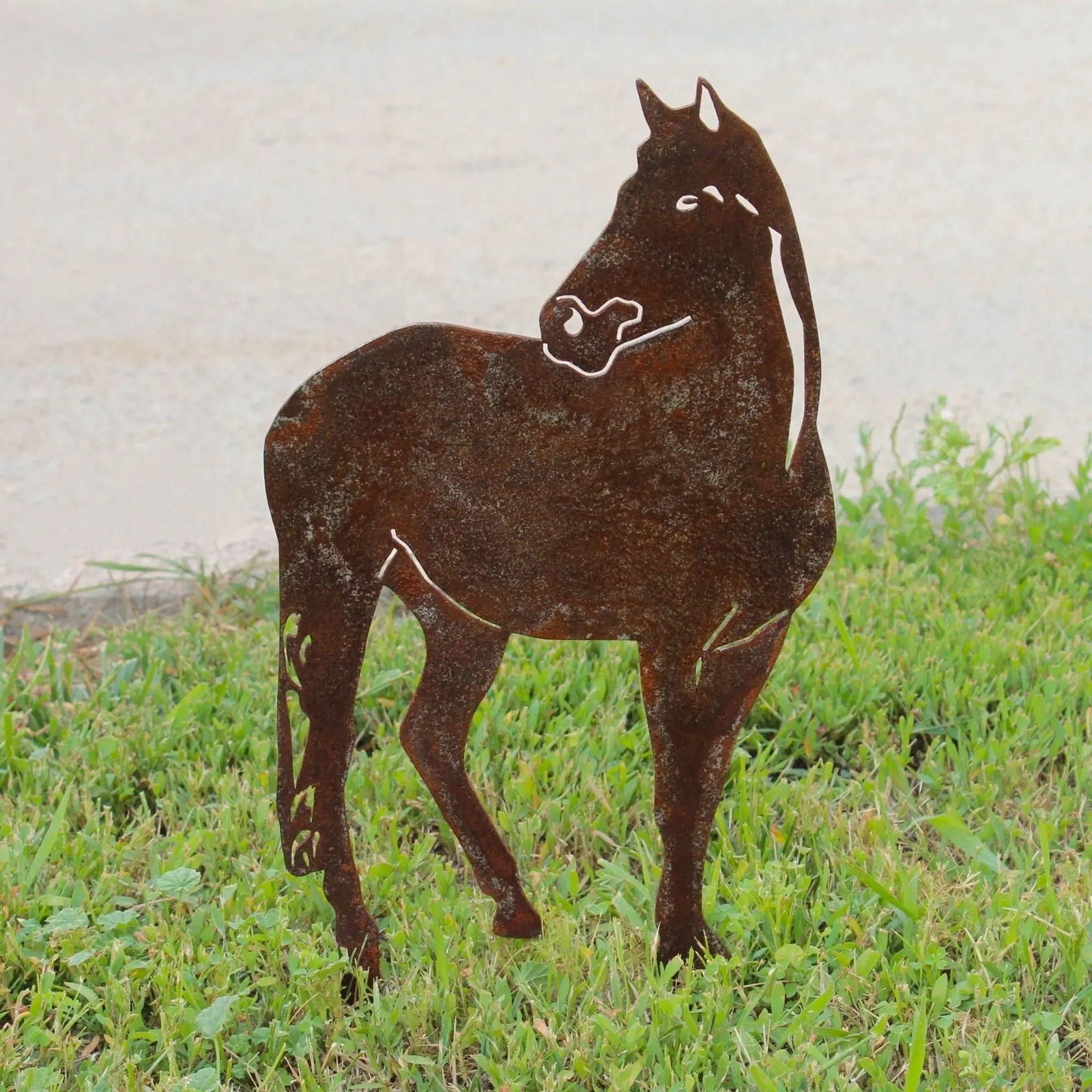 Rusty Corten steel horse silhouette standing in grass, ideal for outdoor garden decor by My Metal Rescue.