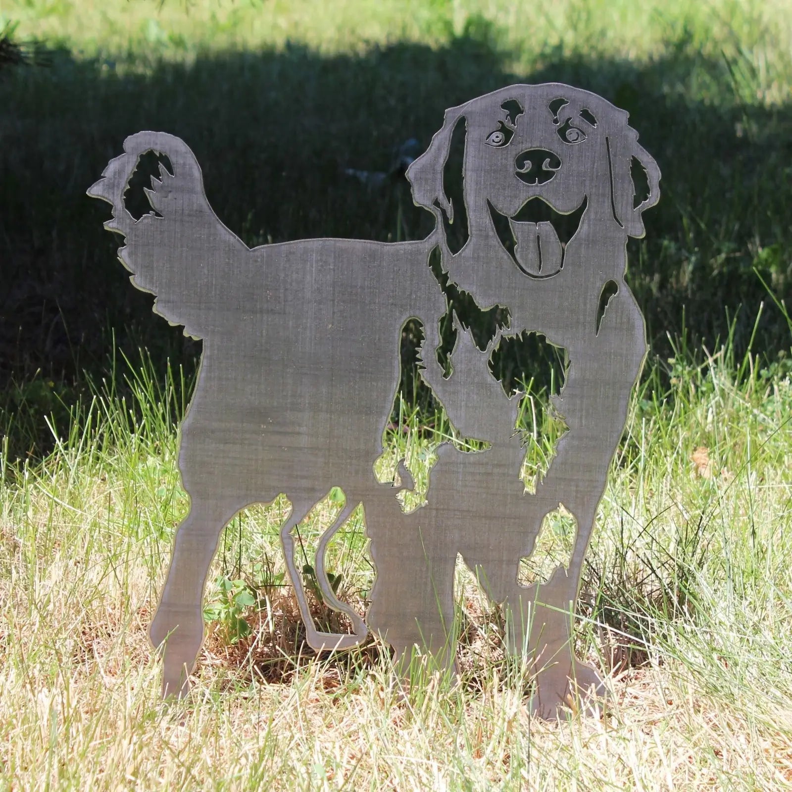 Hovawart dog silhouette in Corten steel, standing among green grass, showcasing a durable, artistic outdoor accent.