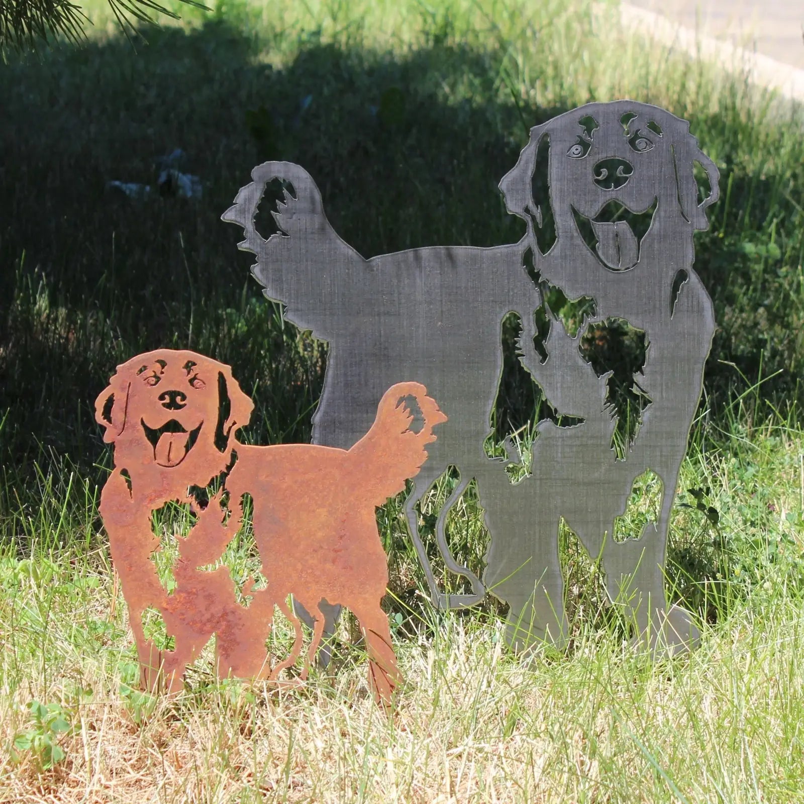 Corten steel and black dog silhouettes in grass, embodying a playful Hovawart design for outdoor decor.