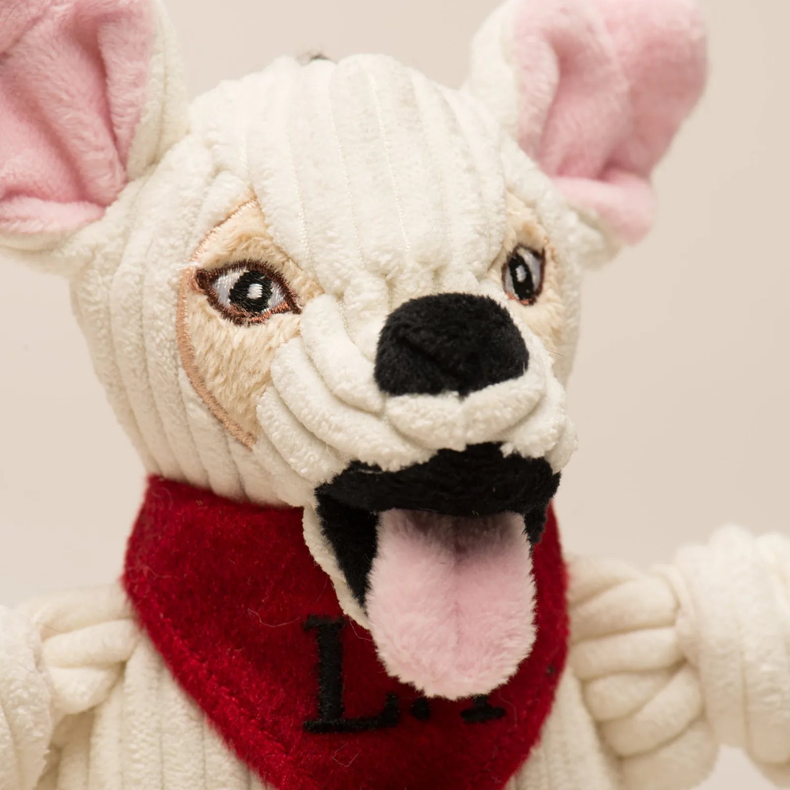 Plush white dog toy with a red bandana, multiple squeakers, and knotted limbs, designed for playful chewing and tugging.