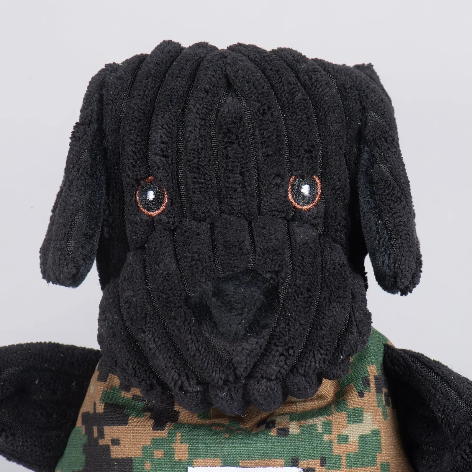 Black Lab Luke Knottie® plush dog toy with textured black fur and camo body, designed for interactive play.