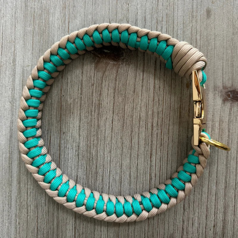 Teal and light tan handmade dog collar with braided design, featuring a sturdy gold D-ring for leash attachment.