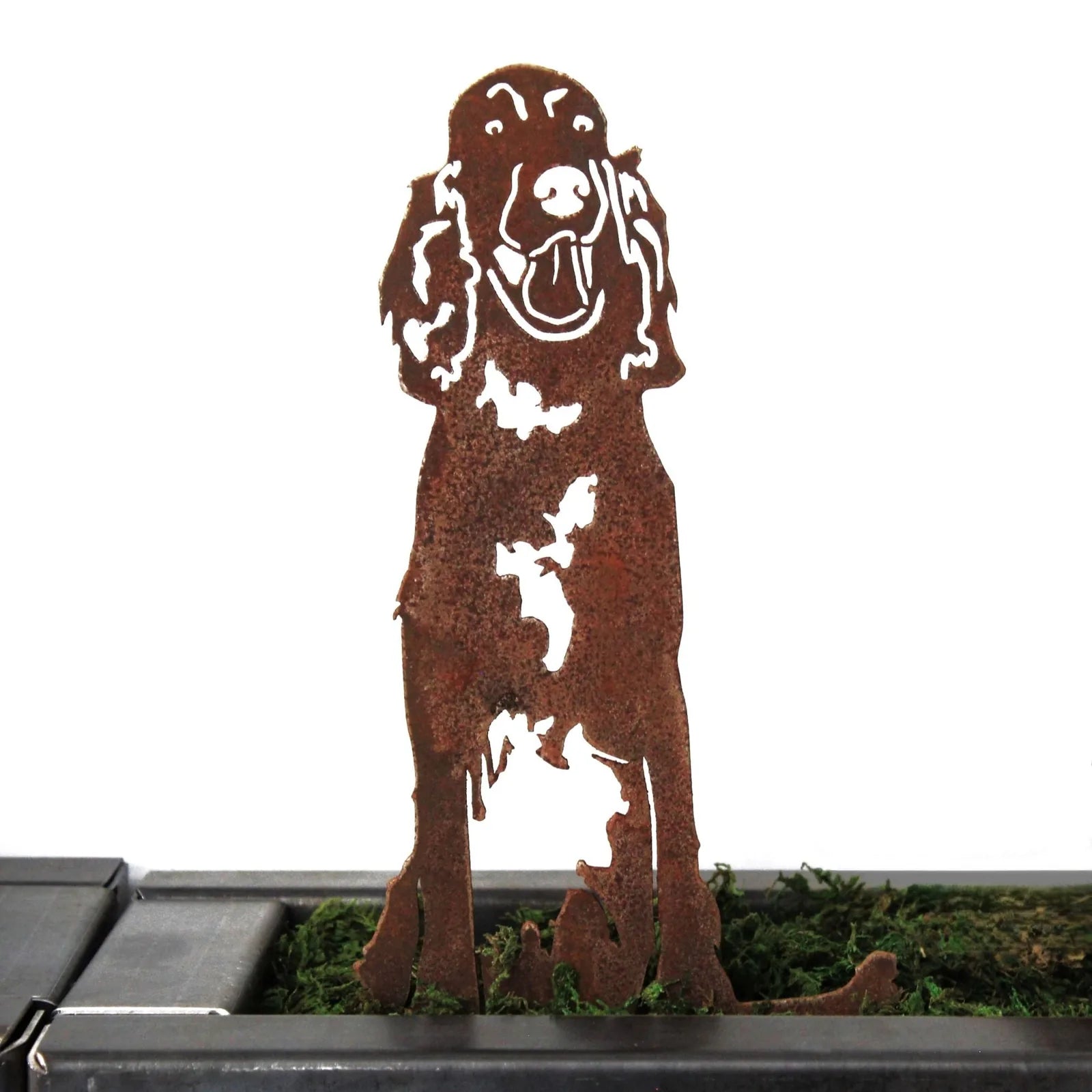 Rusty Corten steel silhouette of an Irish Setter, showcasing detailed features and playful stance, set in green moss.