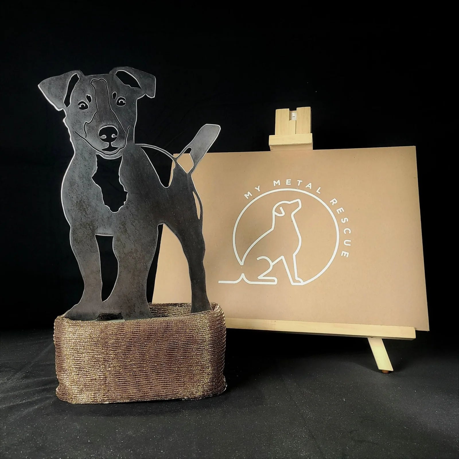Jack Russell Terrier metal silhouette in Corten steel, showcasing detailed design on a woven base, with My Metal Rescue logo.