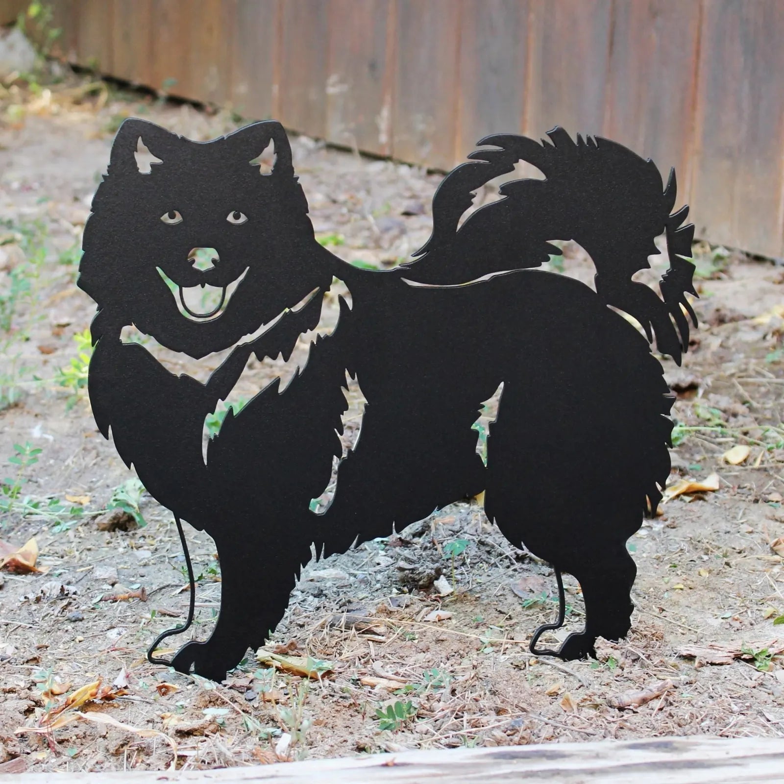 Keeshond silhouette in matte black, made from durable metal, designed for garden or yard decoration.