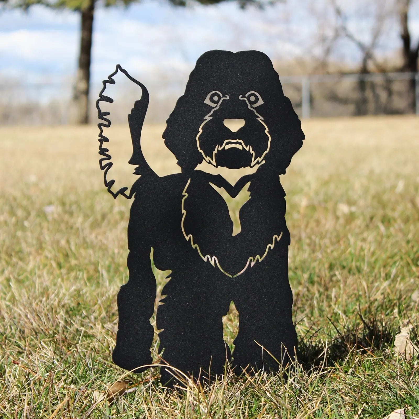 Labradoodle metal silhouette in matte black, standing in grass with a simple and rustic design.