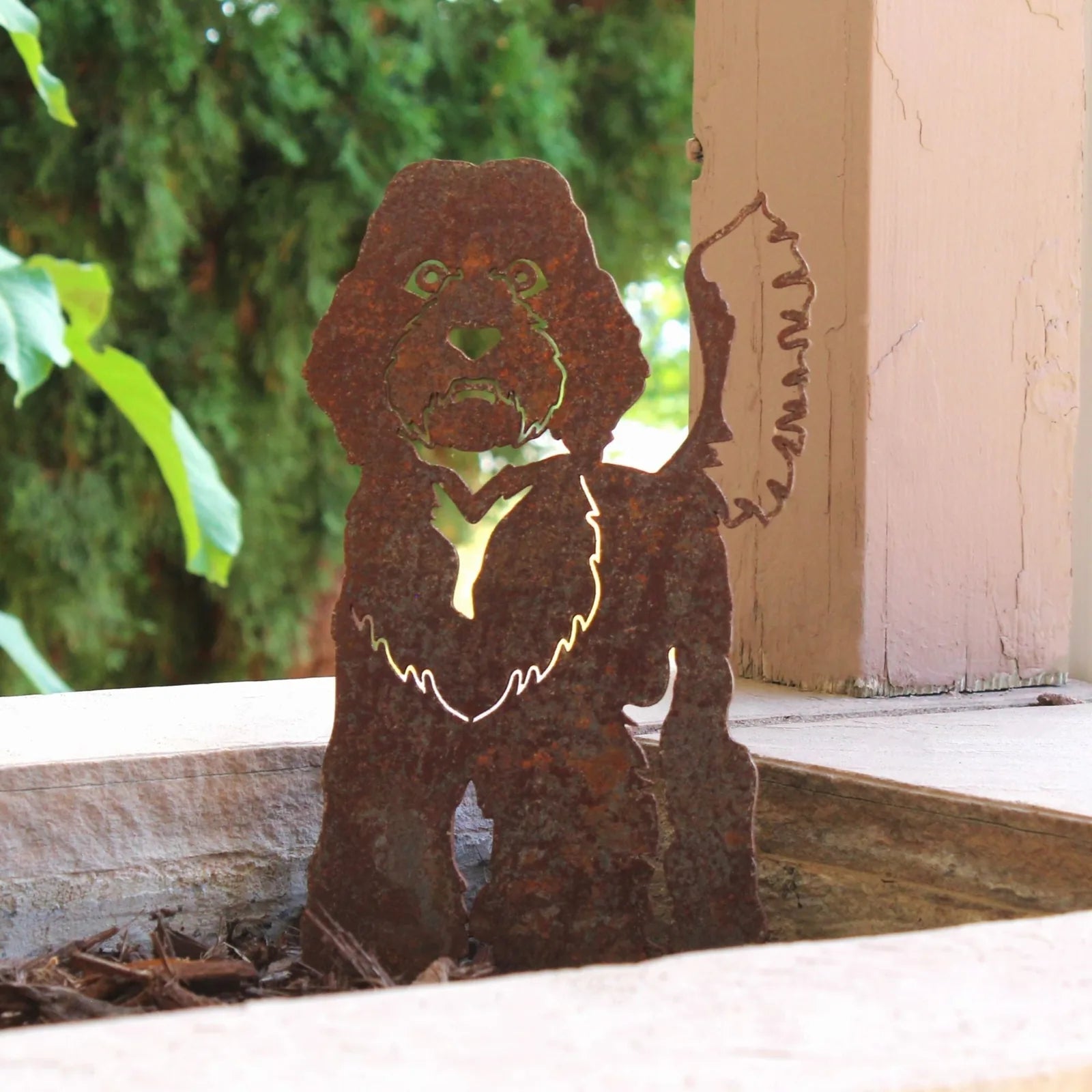 Rusty Corten steel Labradoodle silhouette standing in garden mulch, featuring detailed cutouts and a rustic design.