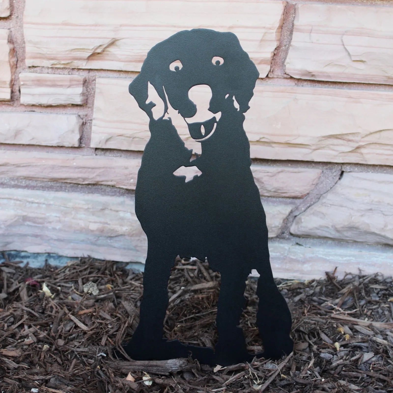 Black metal silhouette of a Labrador Retriever standing on mulch, showcasing handcrafted dog décor for indoor or outdoor use.