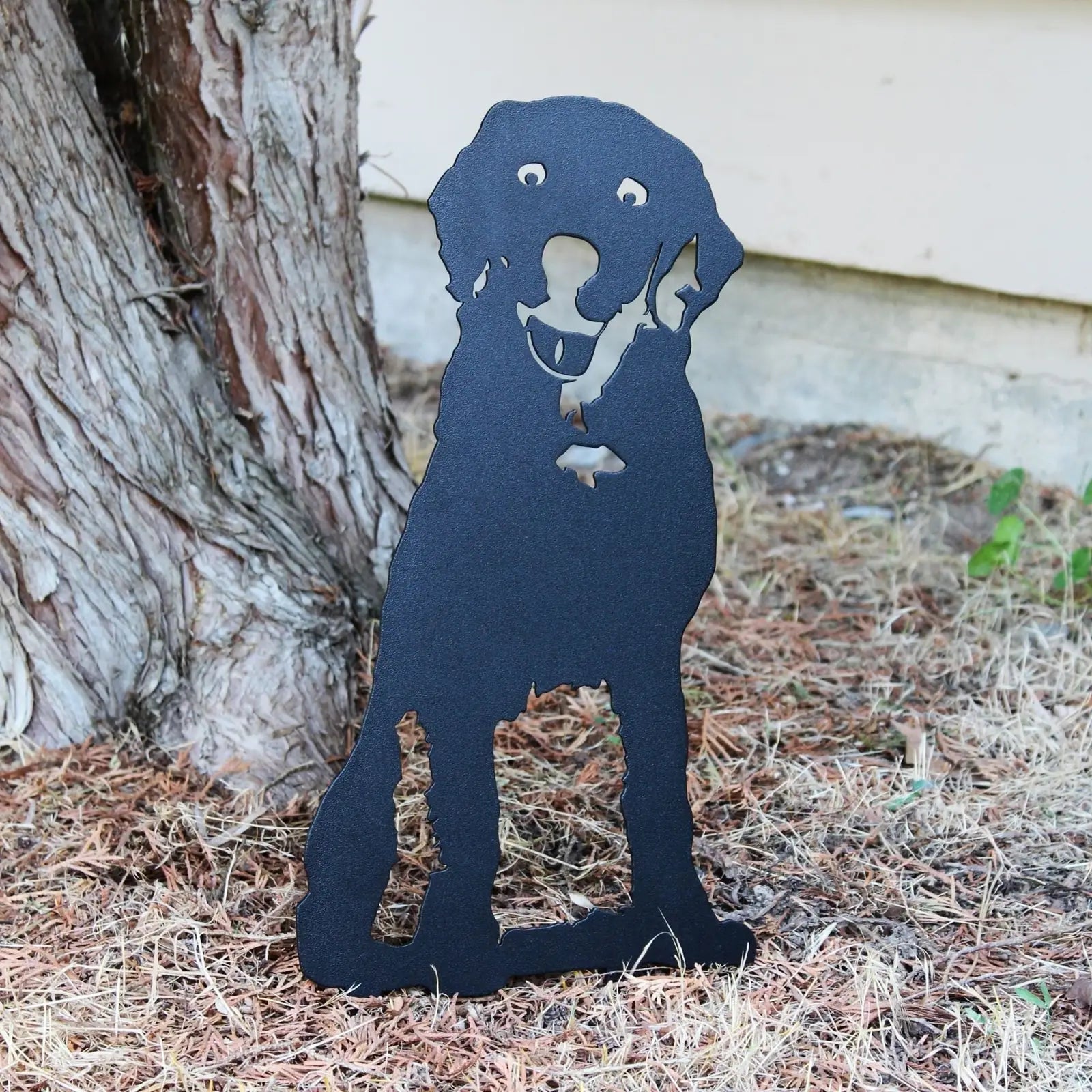 Handcrafted black metal silhouette of a Labrador Retriever, designed for outdoor décor, set against a natural backdrop.