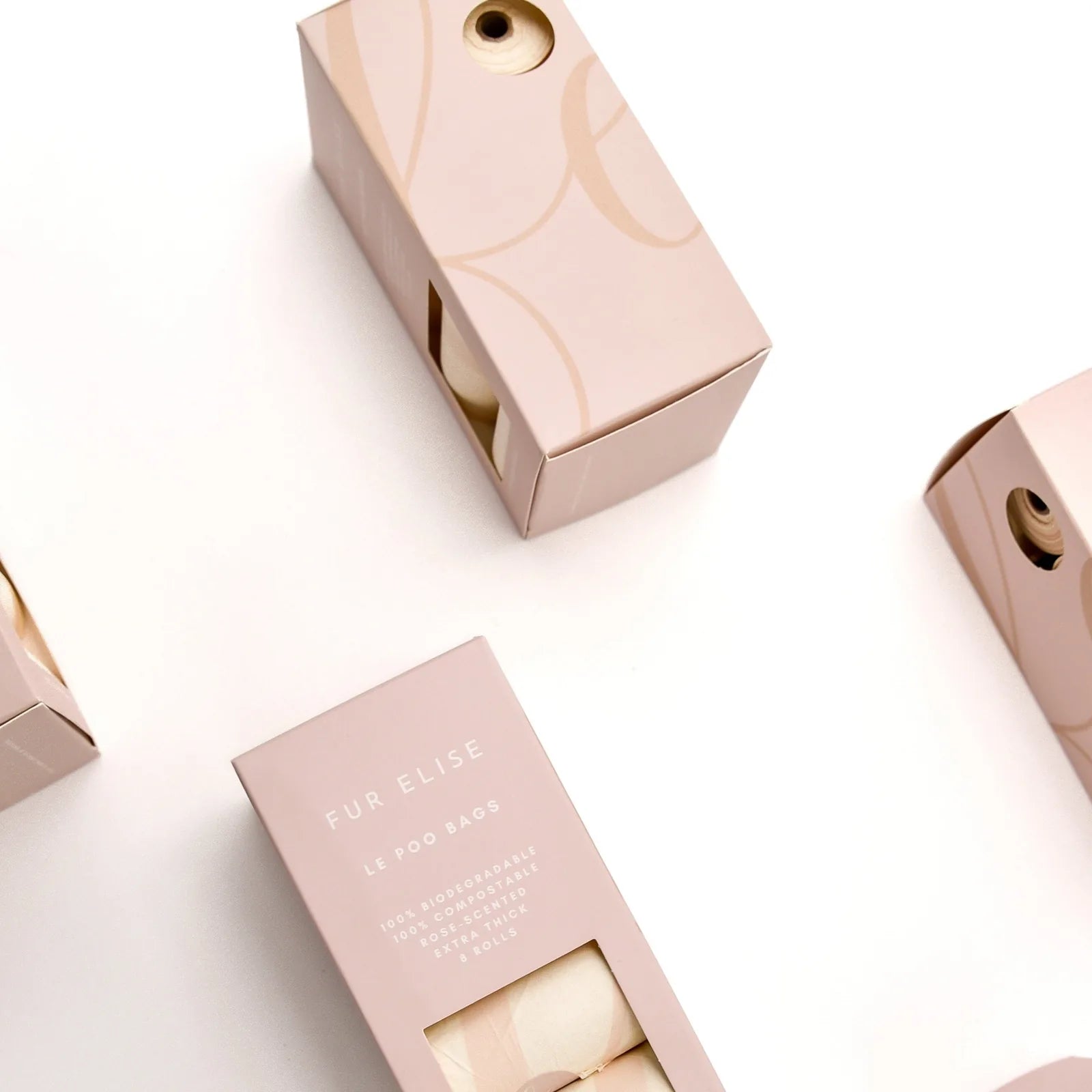 Biodegradable pet waste bags in elegant light pink packaging, featuring a peek-through opening for easy access.