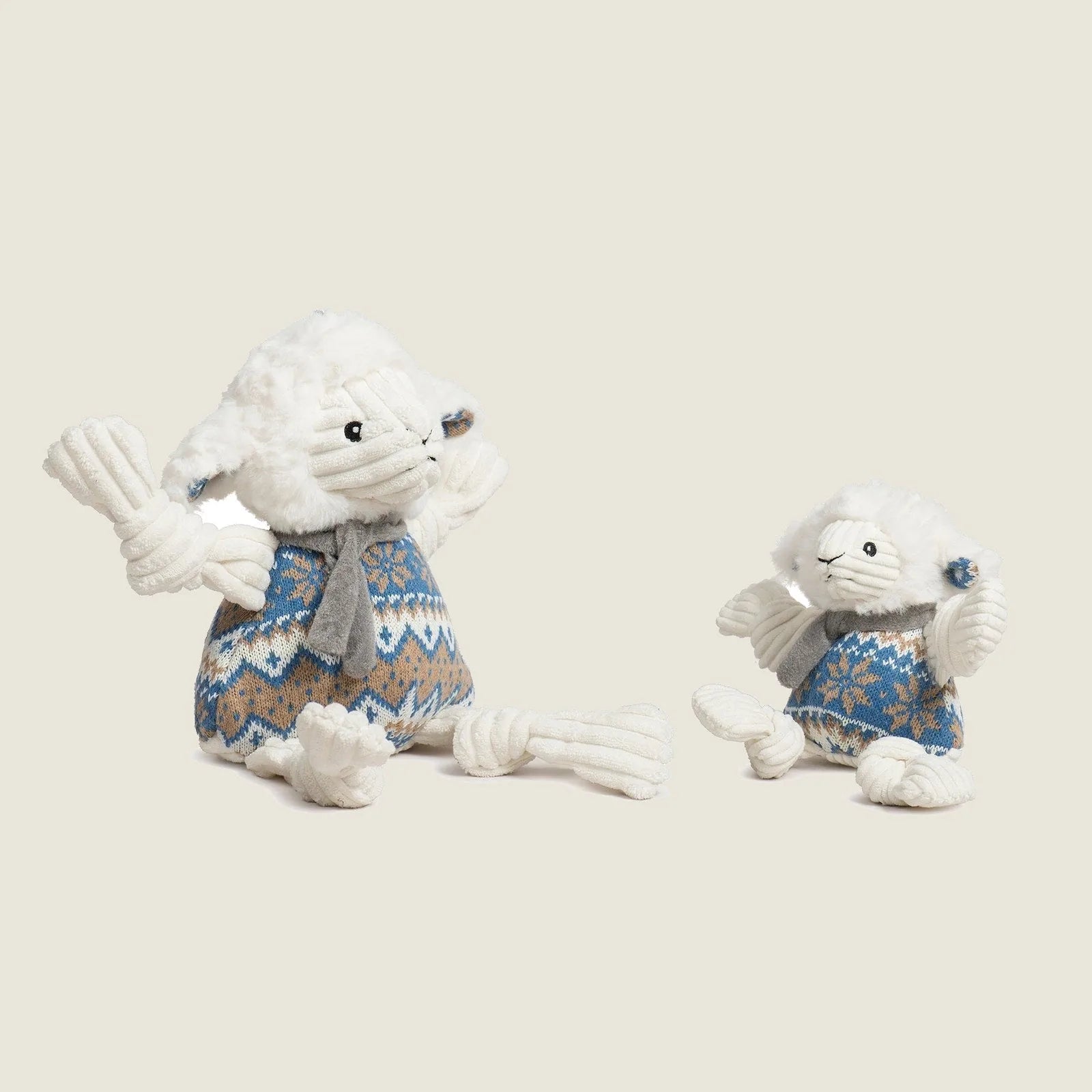 Soft ivory plush Leo Lamb toy with a blue knit sweater, featuring knotted limbs and a cheerful expression.