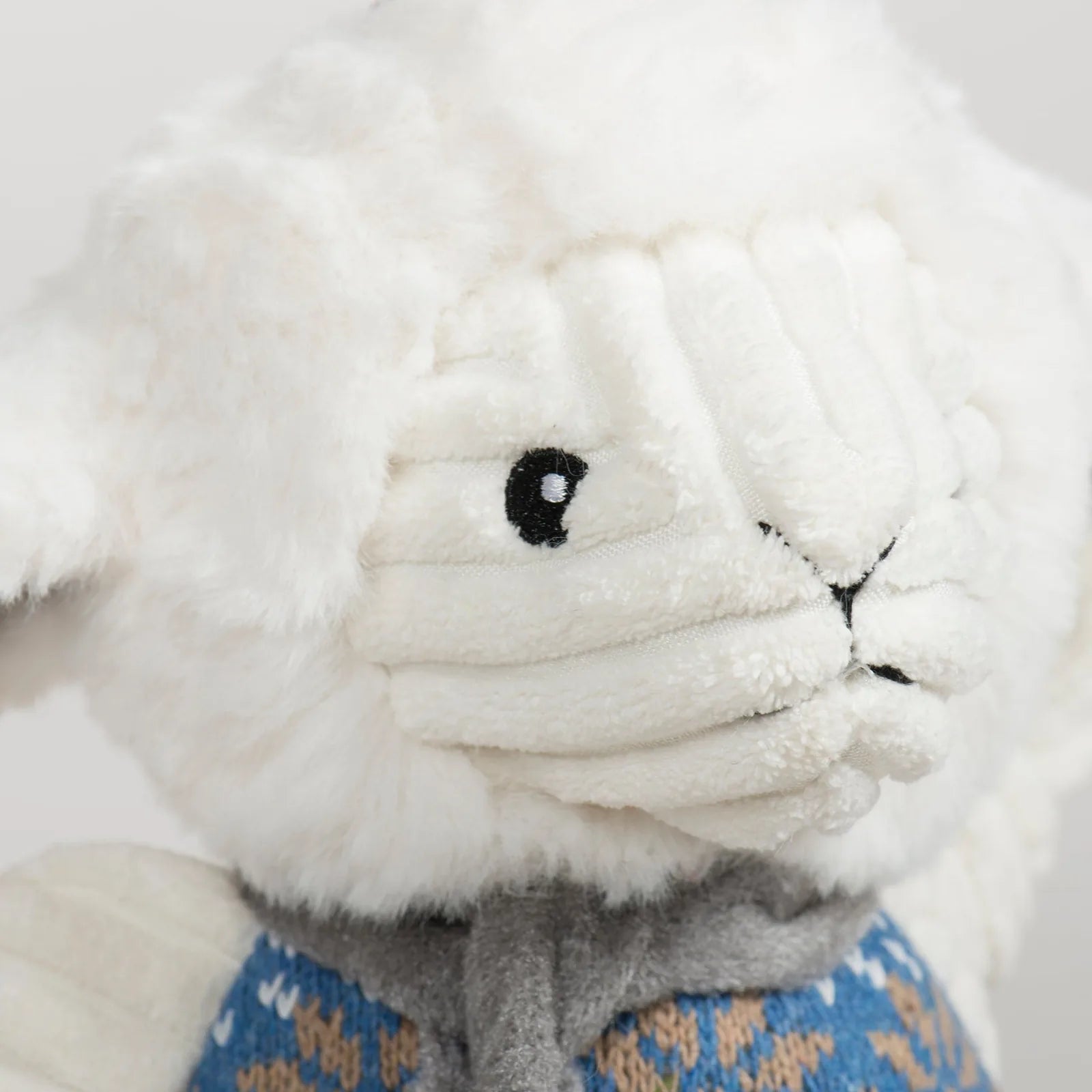 Soft ivory Leo Lamb plush dog toy with a Nordic blue sweater and knotted limbs, perfect for gentle play and snuggling.