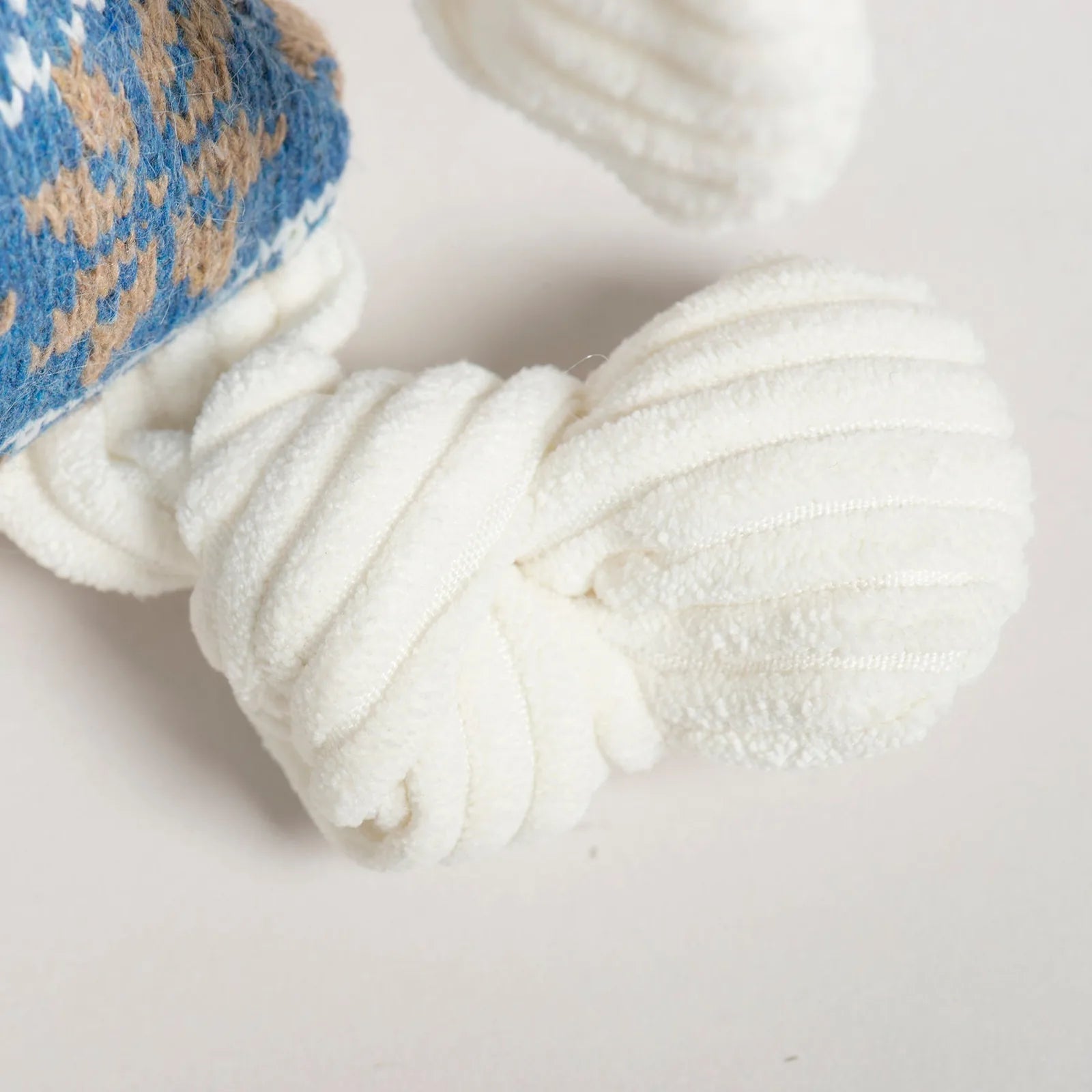 White knotted limbs of the Leo Lamb Knottie® plush toy, showcasing its soft texture and snug design.