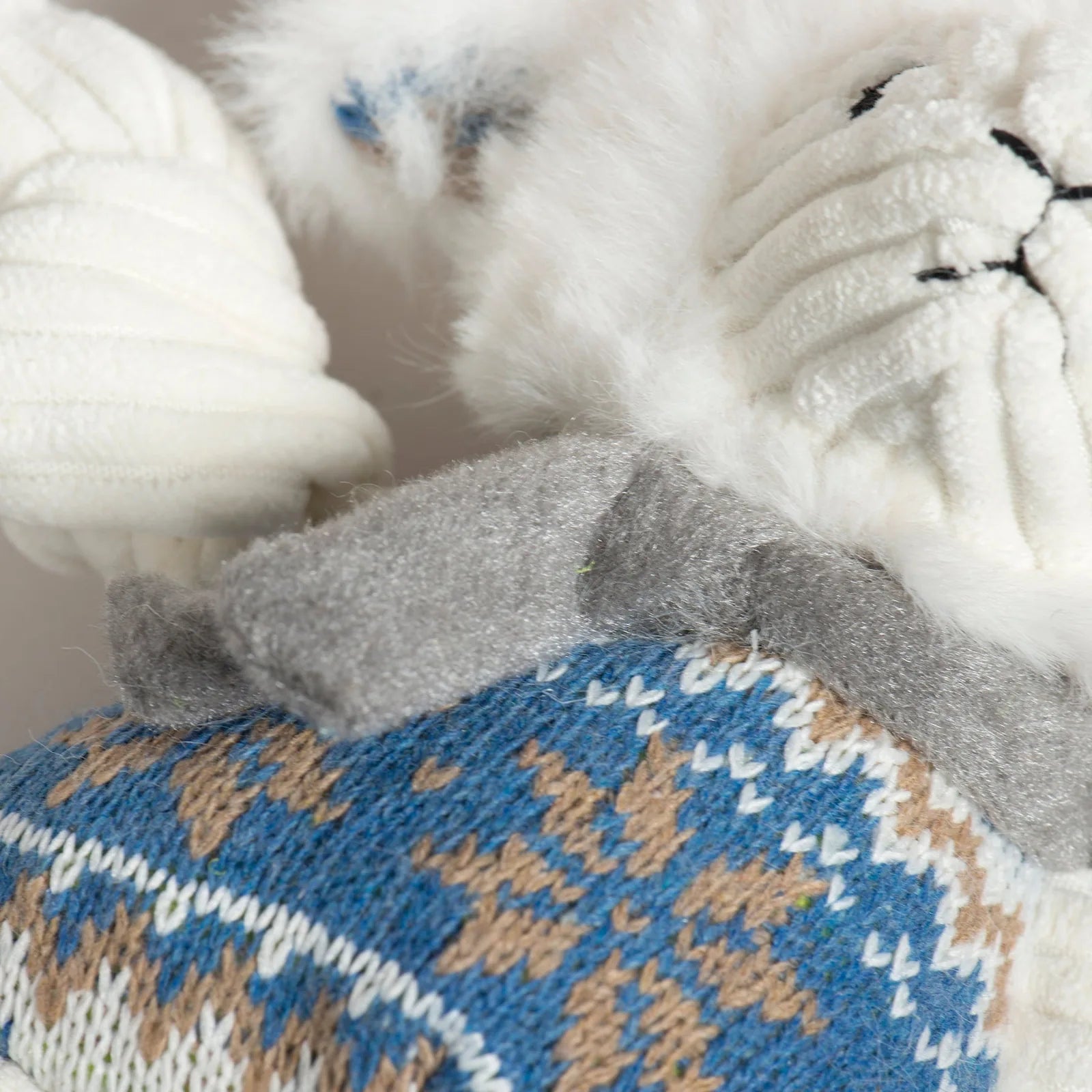 Leo Lamb Knottie® features soft ivory fur, a Nordic blue sweater with festive patterns, and knotted limbs for play.