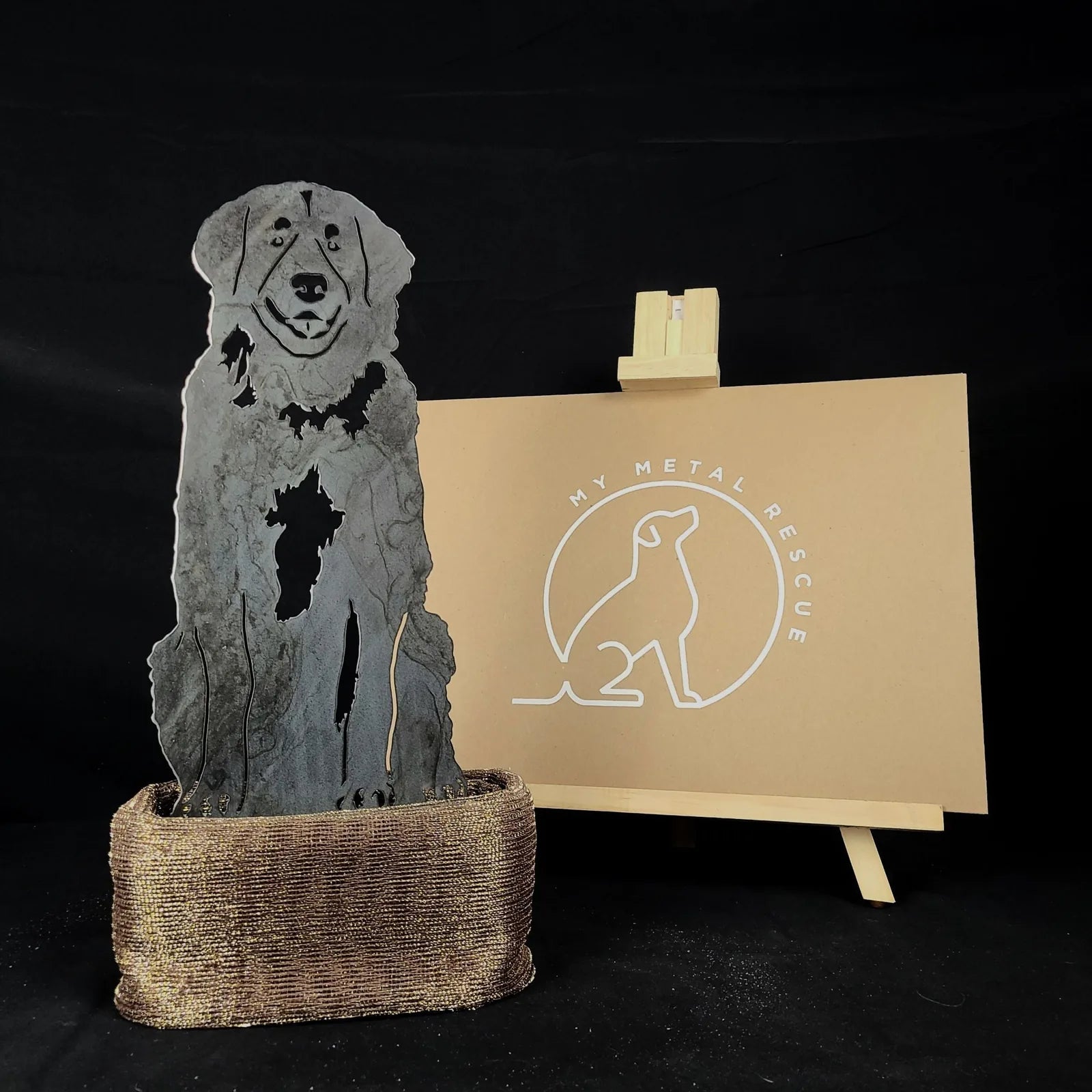 Leonberger metal silhouette in Corten steel displayed in a textured bronze pot with a My Metal Rescue sign in the background.