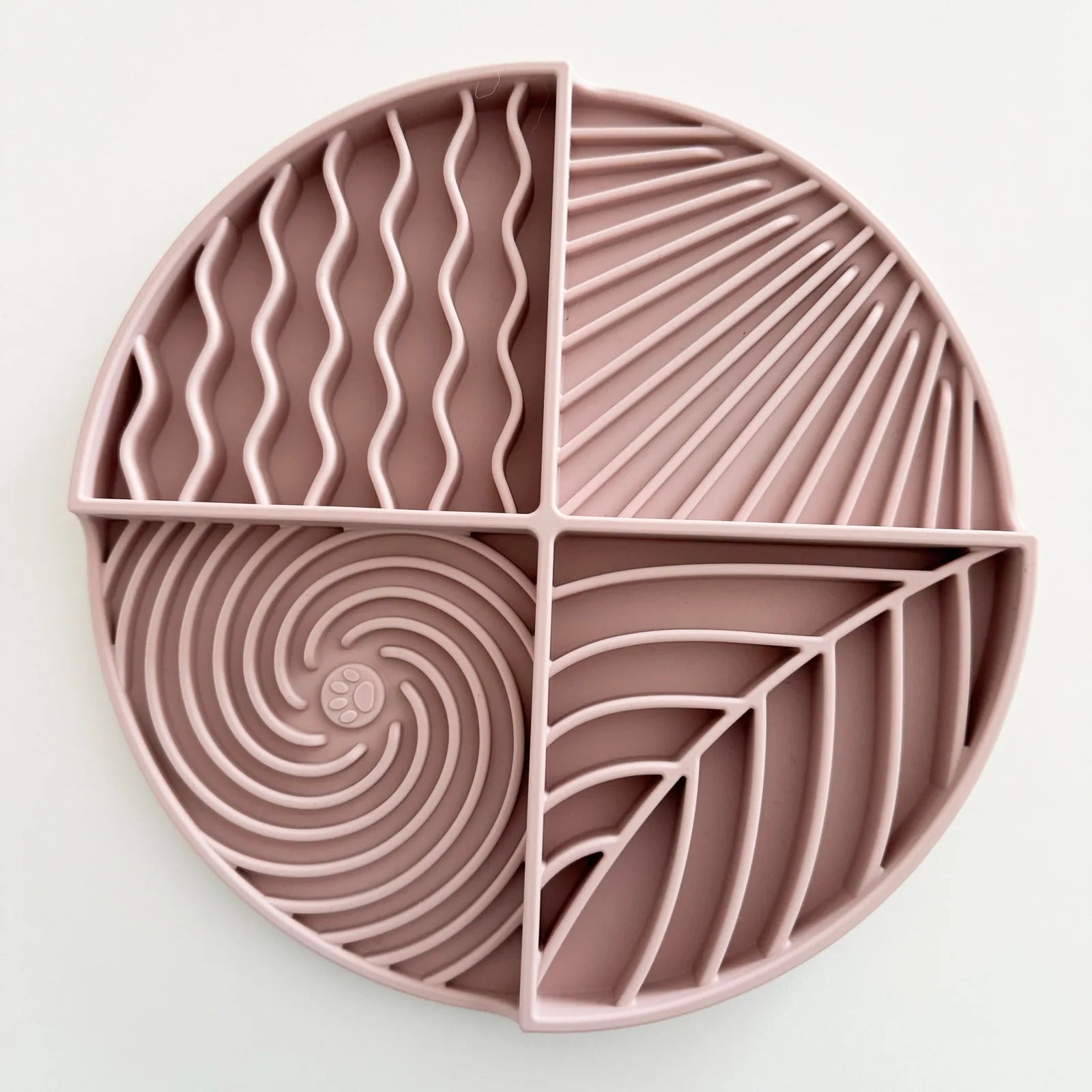 Lick mat in a soft rose color, featuring four textured sections for engaging dog play and mealtime stimulation.