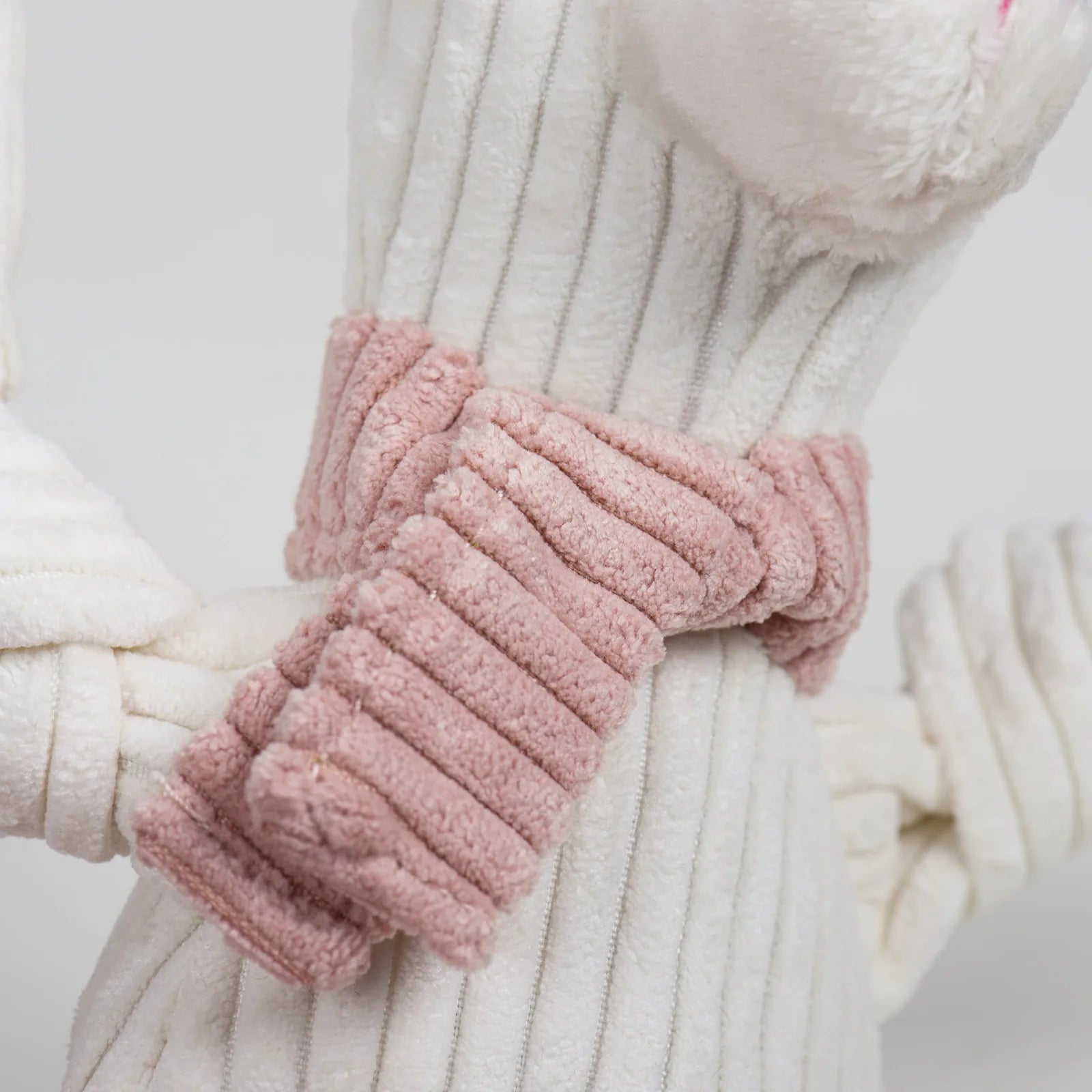 Lillie Llama Knottie® plush dog toy features a soft white texture with a pink ribbed scarf and knotted limbs, perfect for...