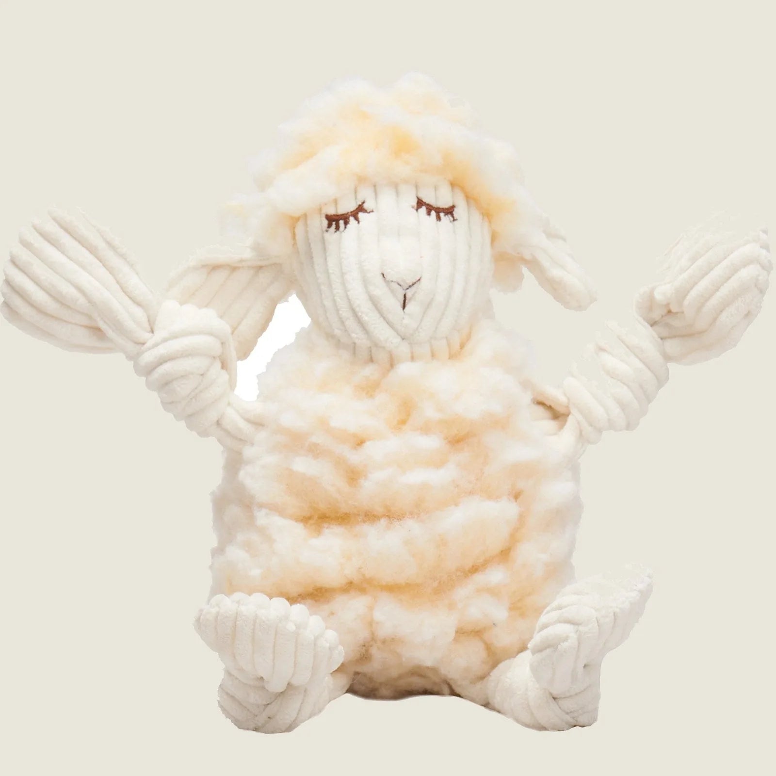Cream-colored plush lamb dog toy with knotted limbs, soft fleece fabric, and a friendly embroidered face.