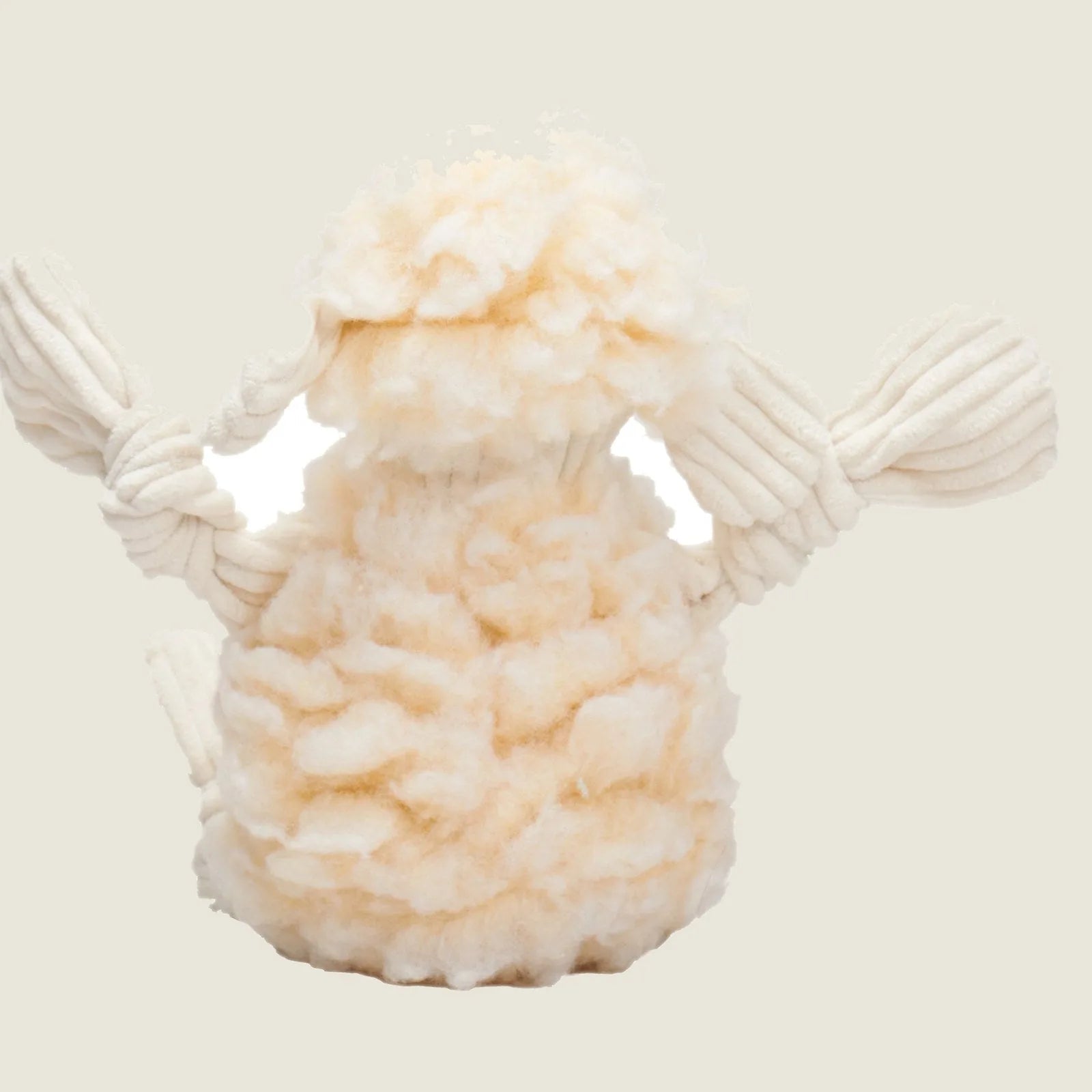 Cream-colored plush dog toy shaped like a lamb, featuring knotted limbs and a soft, fluffy texture.