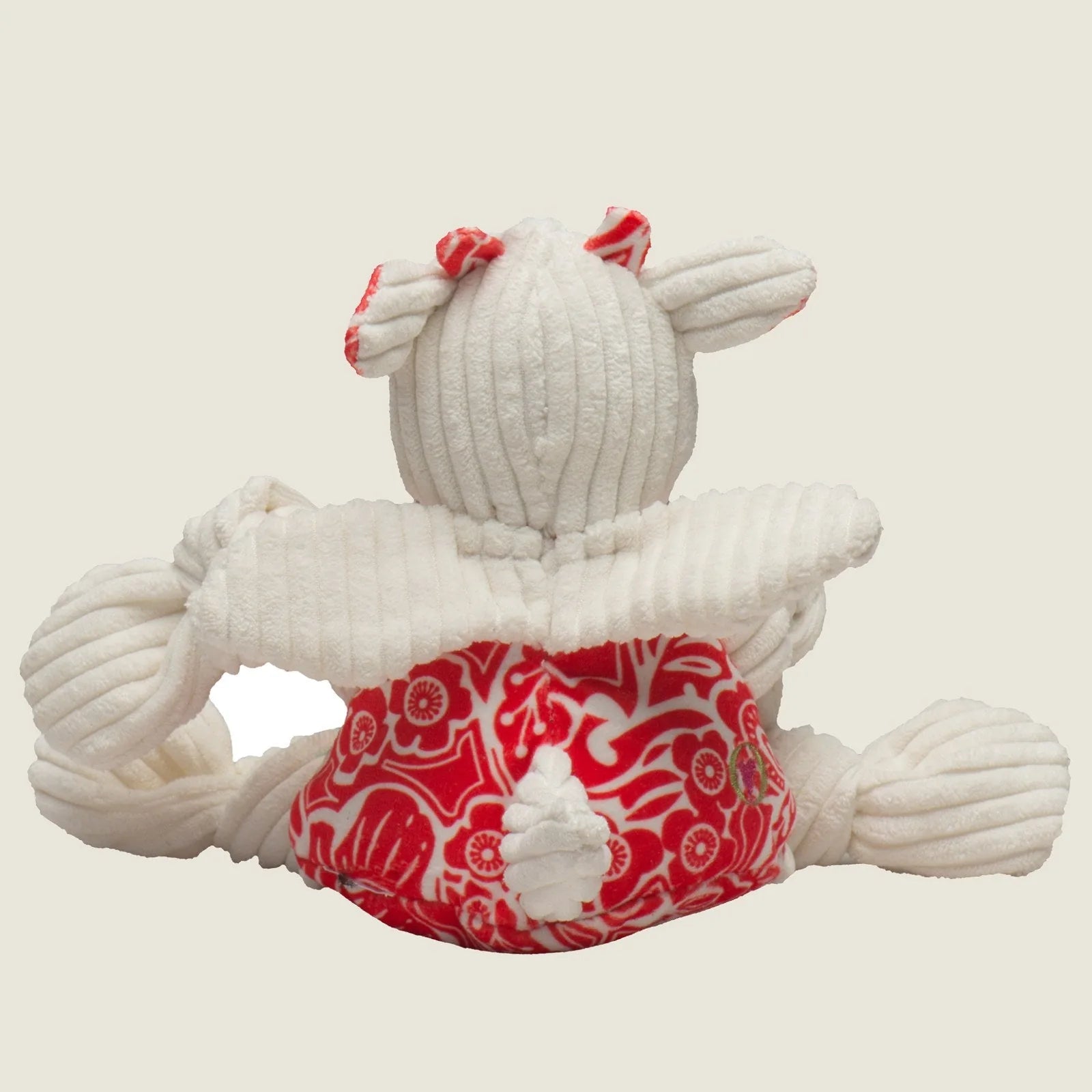 Plush dog toy with a red and white floral pattern, featuring a textured corduroy body and playful ears.