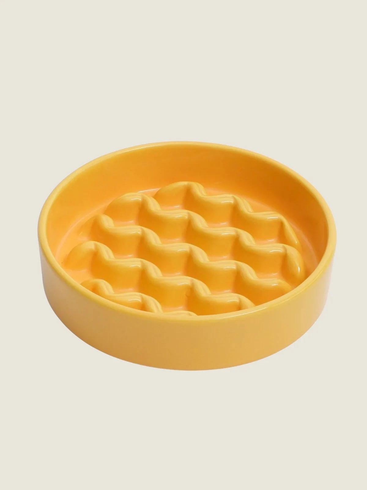 Yellow ceramic slow feeder dog bowl with a wavy interior design, promoting slower eating for better digestion.