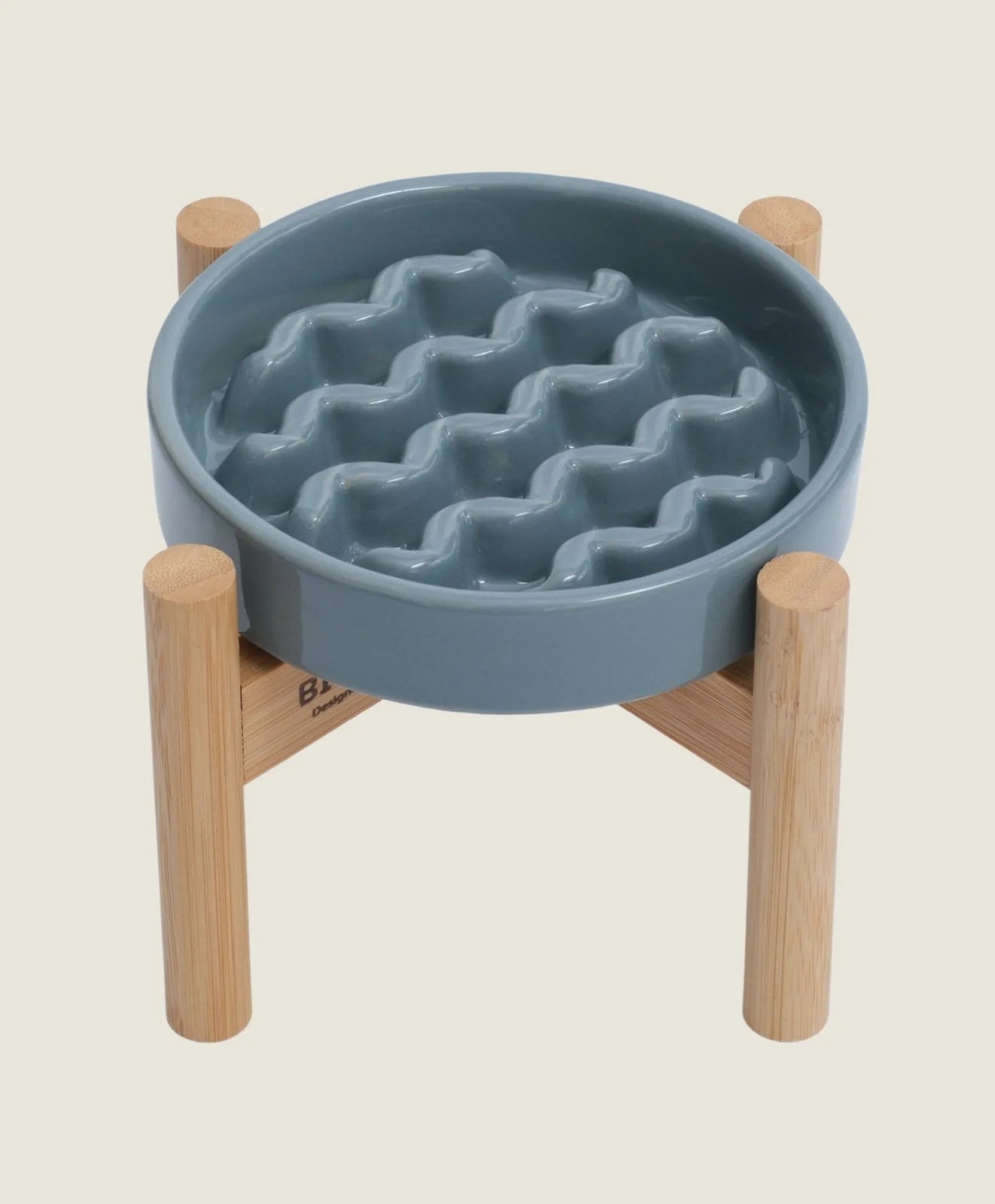Ceramic slow feeder dog bowl in frozen blue color, featuring a wavy design and a wooden stand for stability.