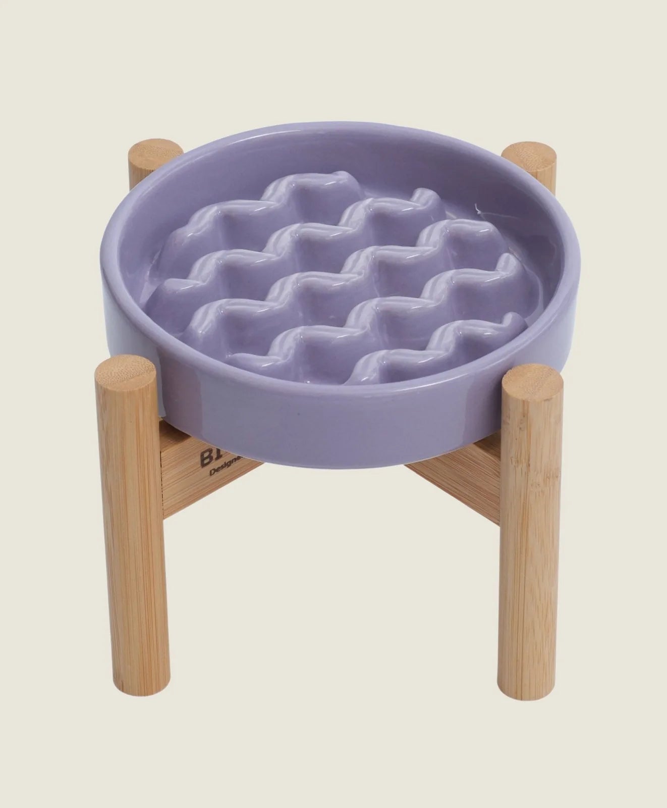 Purple slow feeder dog bowl with a wavy interior pattern, elevated on a bamboo stand for stability.