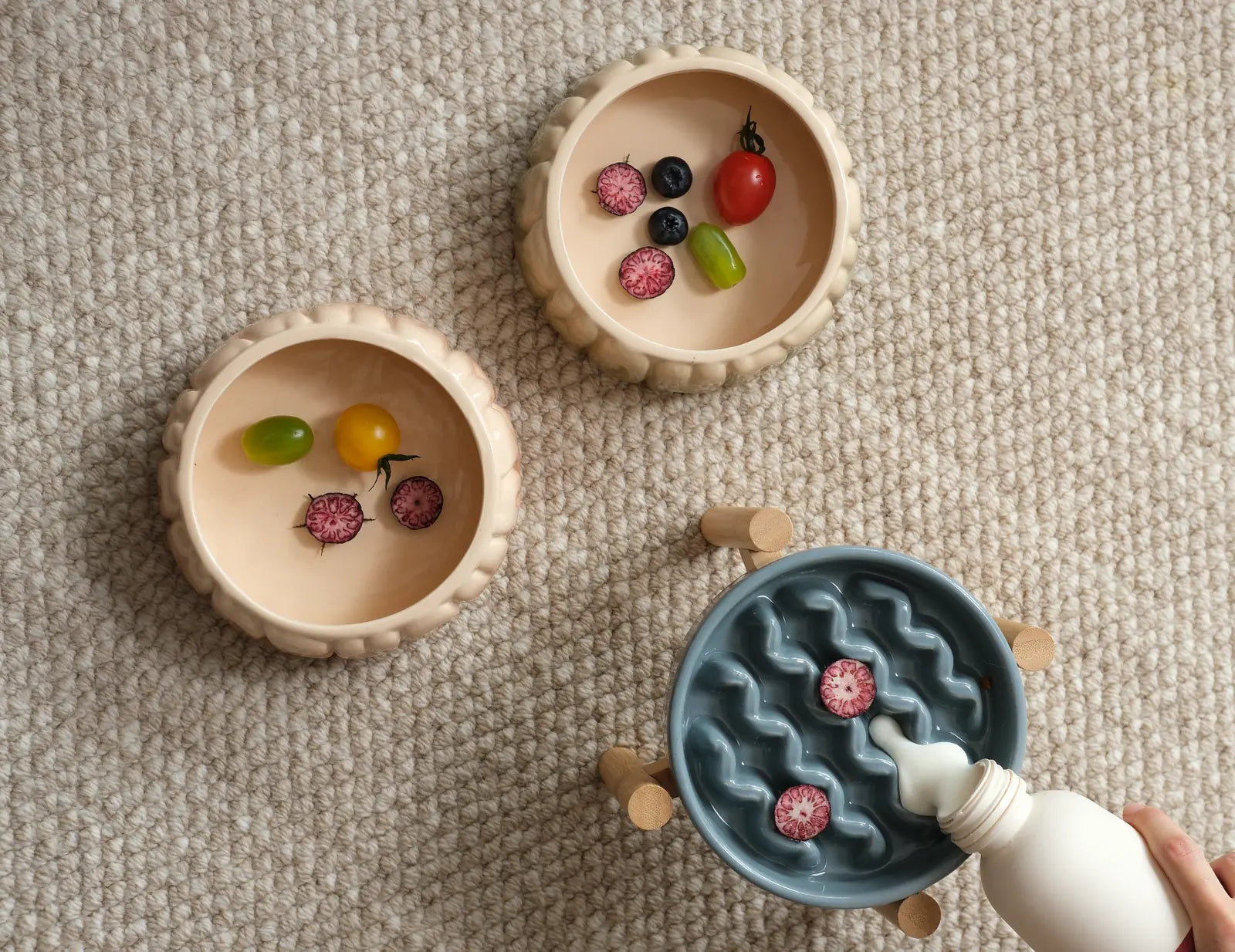 Ceramic slow feeder dog bowls in yellow and blue with decorative fruits, designed for promoting slower eating.