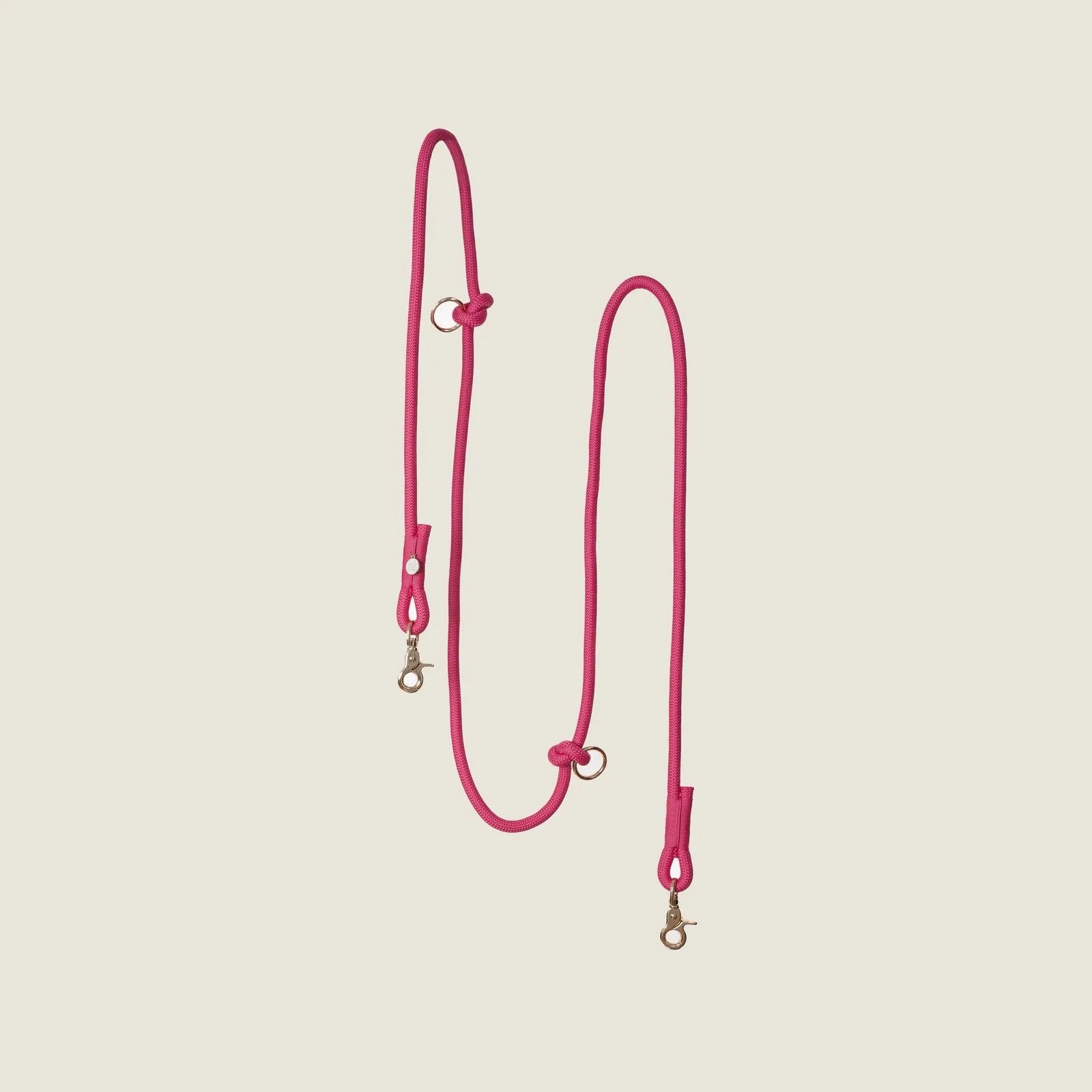 Magenta hands-free braided leash with gold clips, designed for durable and adjustable dog walking.