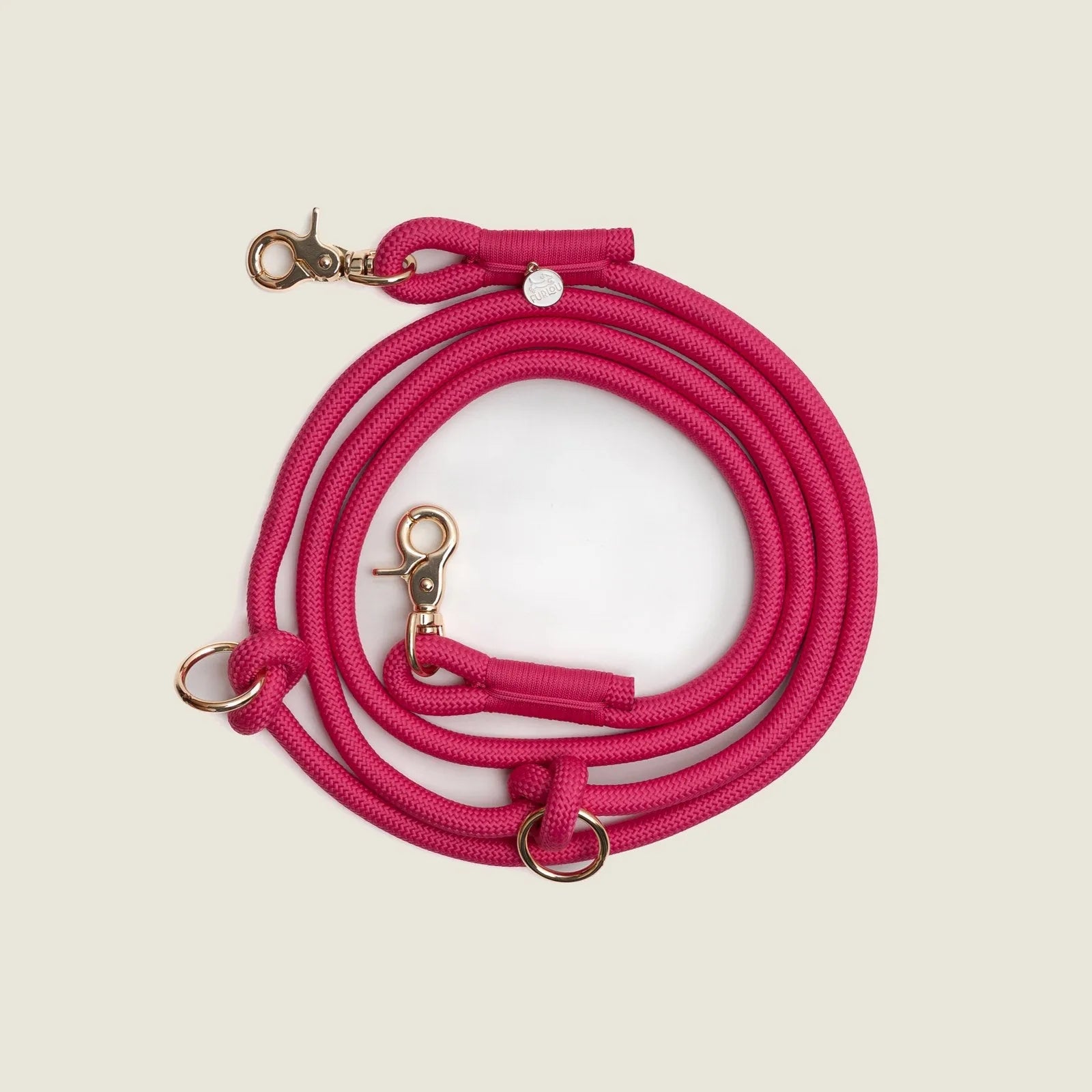 Hands-free braided leash in vibrant magenta with gold hardware, designed for comfort and versatility during dog walks.