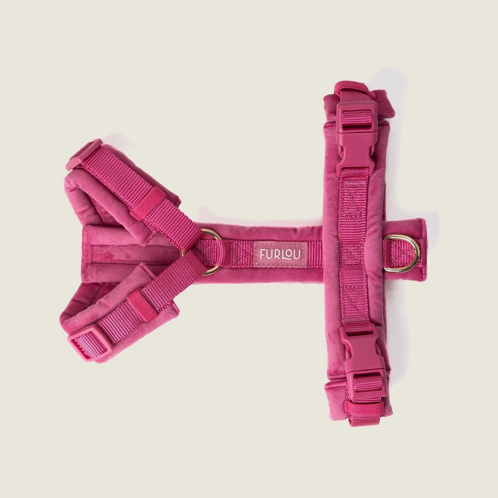 Magenta velvet dog harness with adjustable straps and gold hardware, designed for comfort and style.