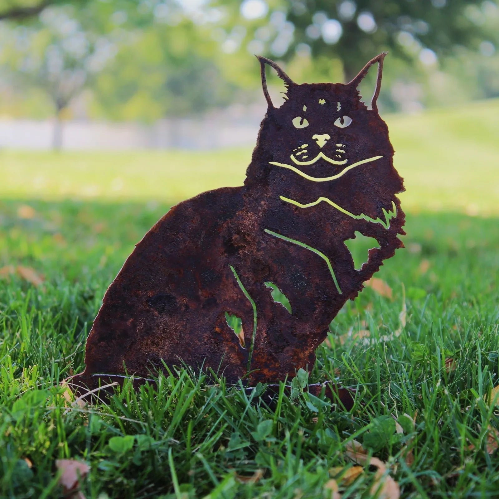 Rusty Corten steel Maine Coon silhouette in grass, showcasing a detailed cat design for outdoor decor.