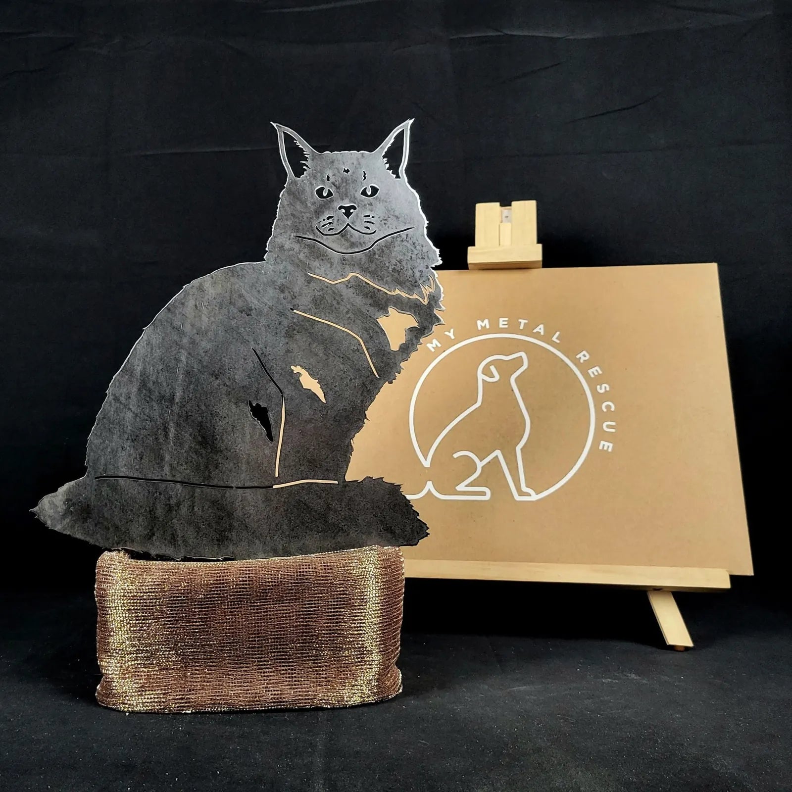 Maine Coon metal silhouette in matte black with a textured base, showcasing a rustic outdoor decor design.
