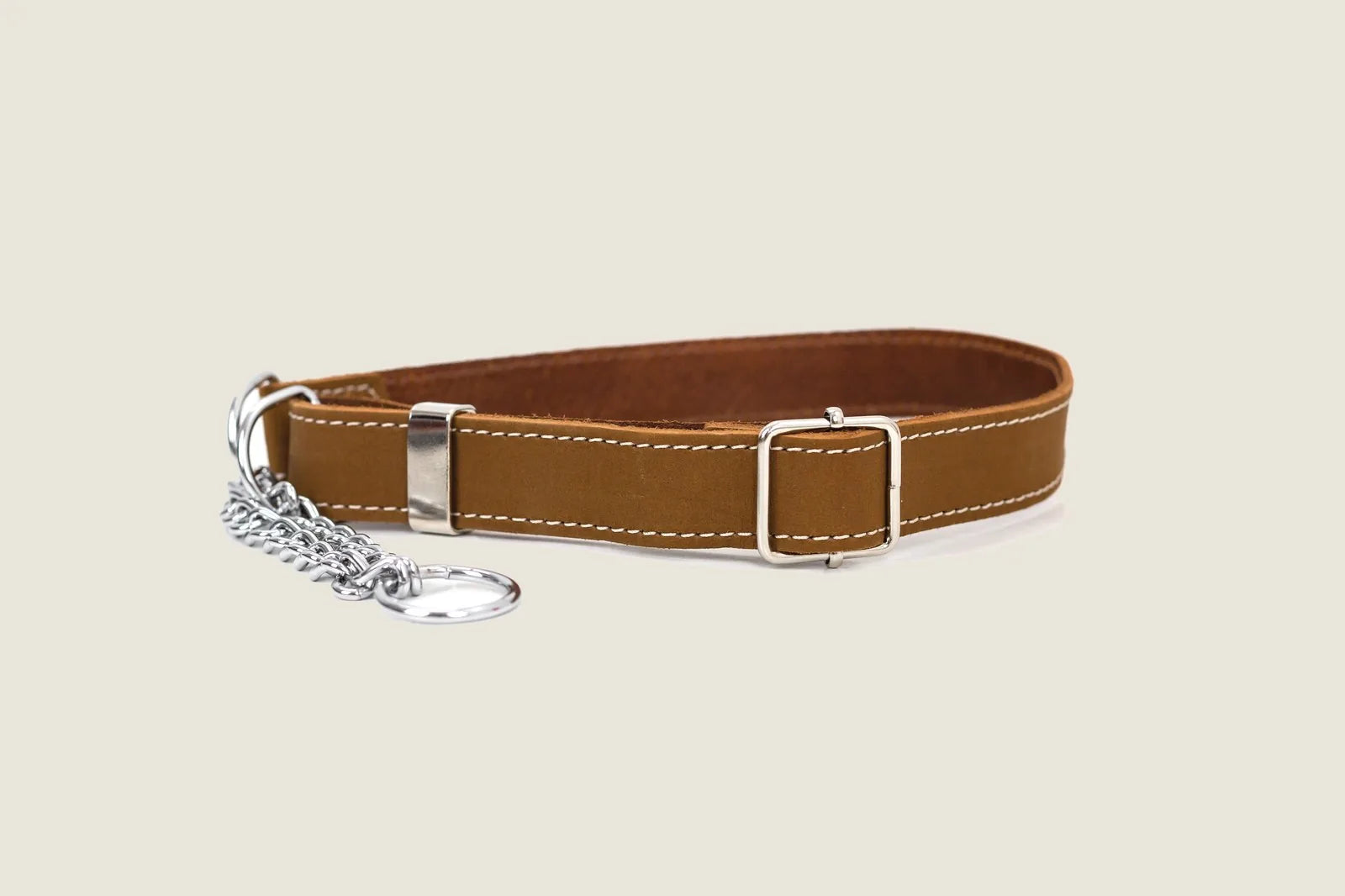 Martingale collar in earth brown leather with white stitching and steel hardware, designed for gentle control during walks.