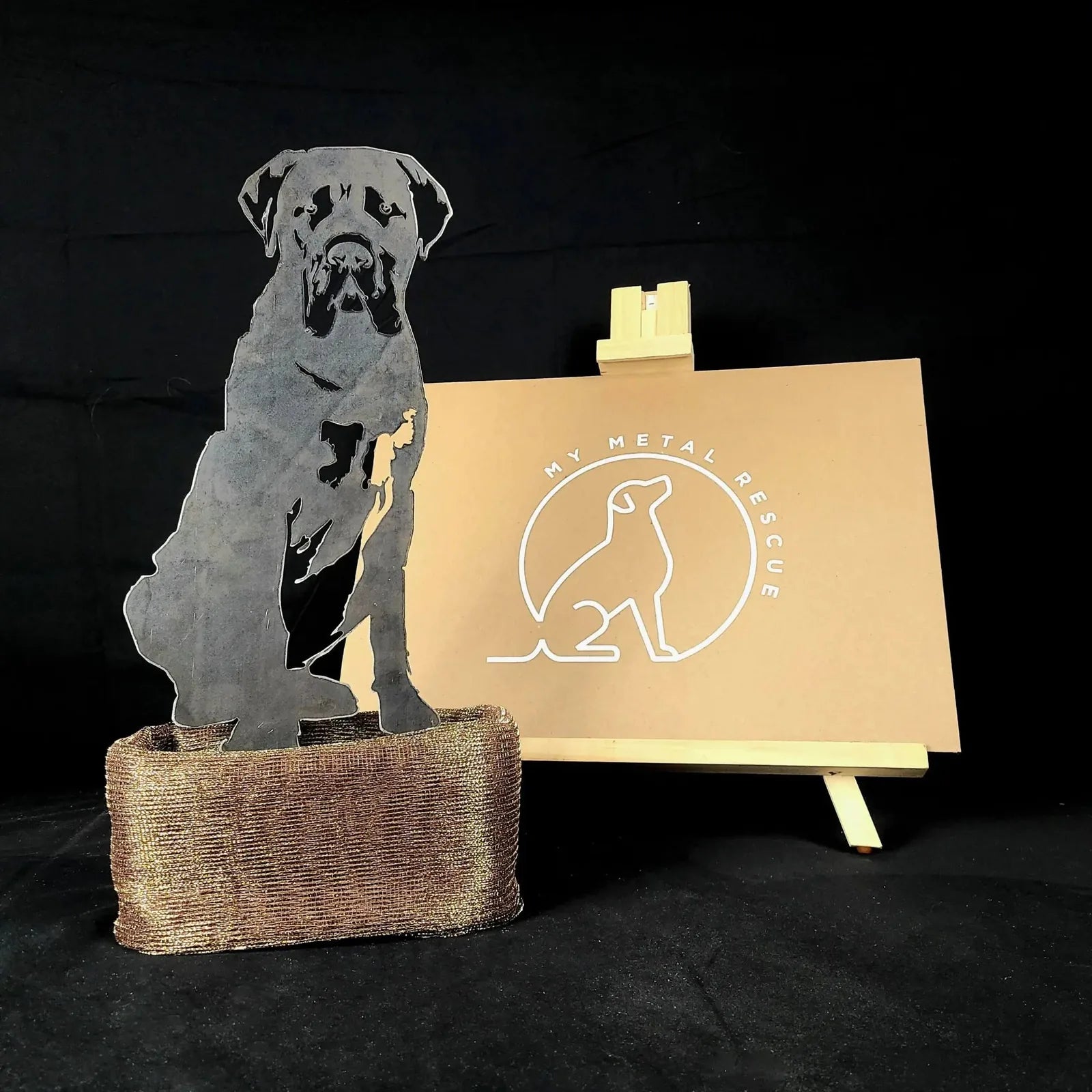 Mastiff silhouette in black metal, showcased with a natural fiber base, against a neutral backdrop.