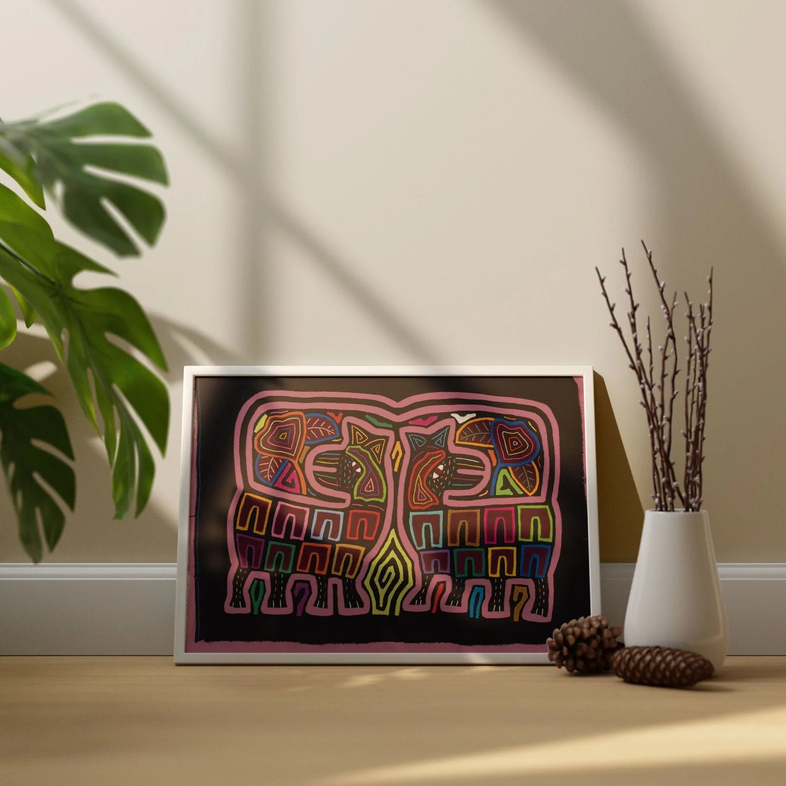 Hand-stitched colorful Mola artwork featuring geometric patterns on a dark background, framed and displayed decoratively.