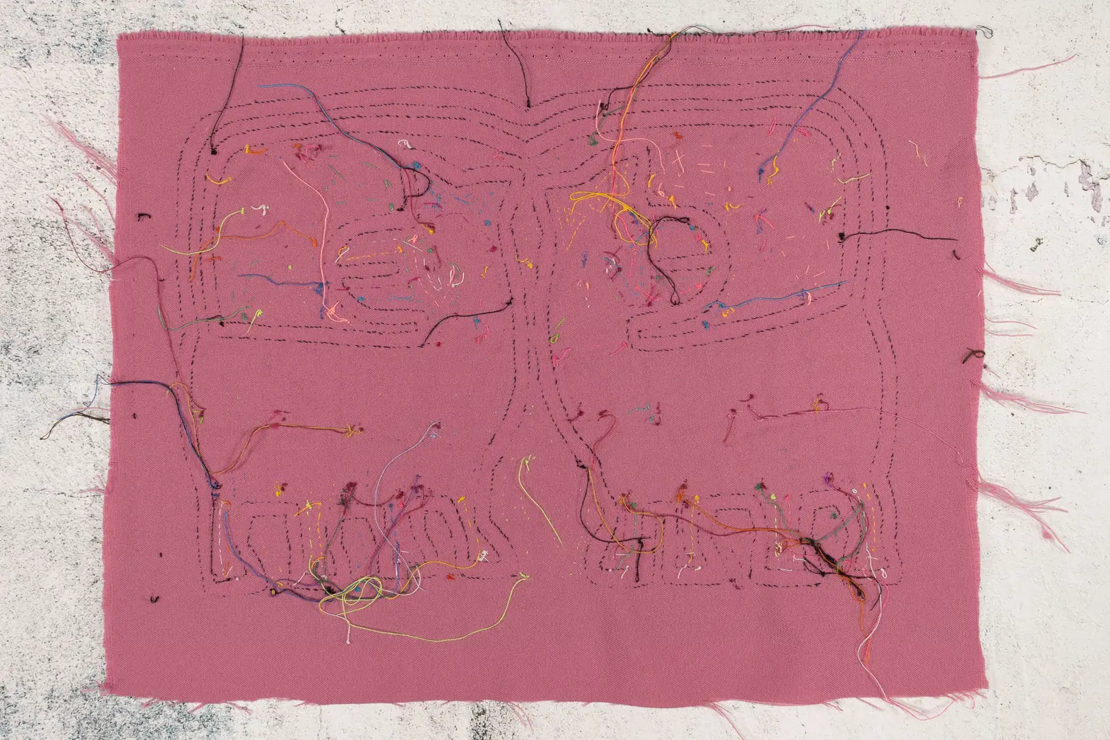 Hand-stitched pink Mola featuring colorful threads and geometric patterns, showcasing traditional Panama textile art.
