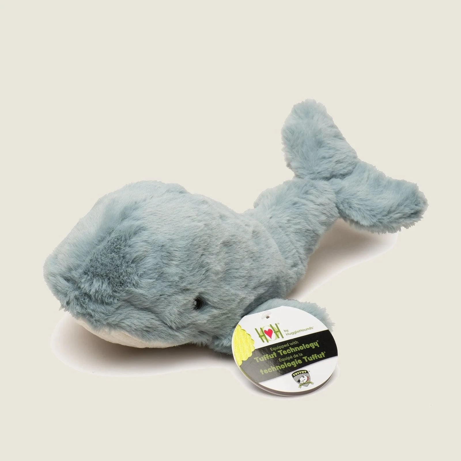Soft plush whale toy in a light blue color, featuring a knotted design and tag indicating Tuffut Technology® for durability.