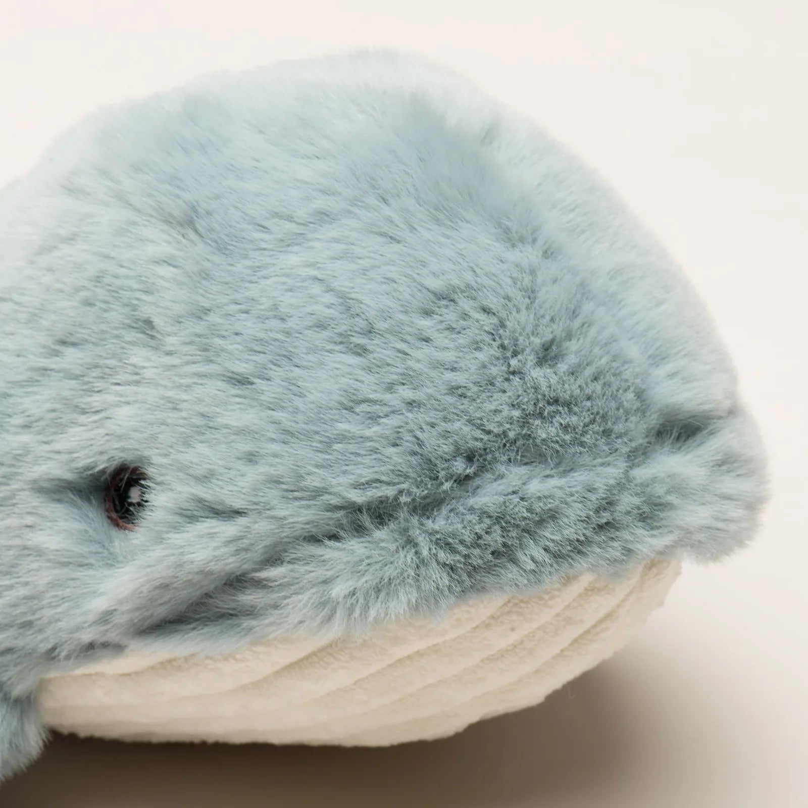 Soft plush whale toy in light blue and cream, featuring a knotted design and gentle texture for dogs.