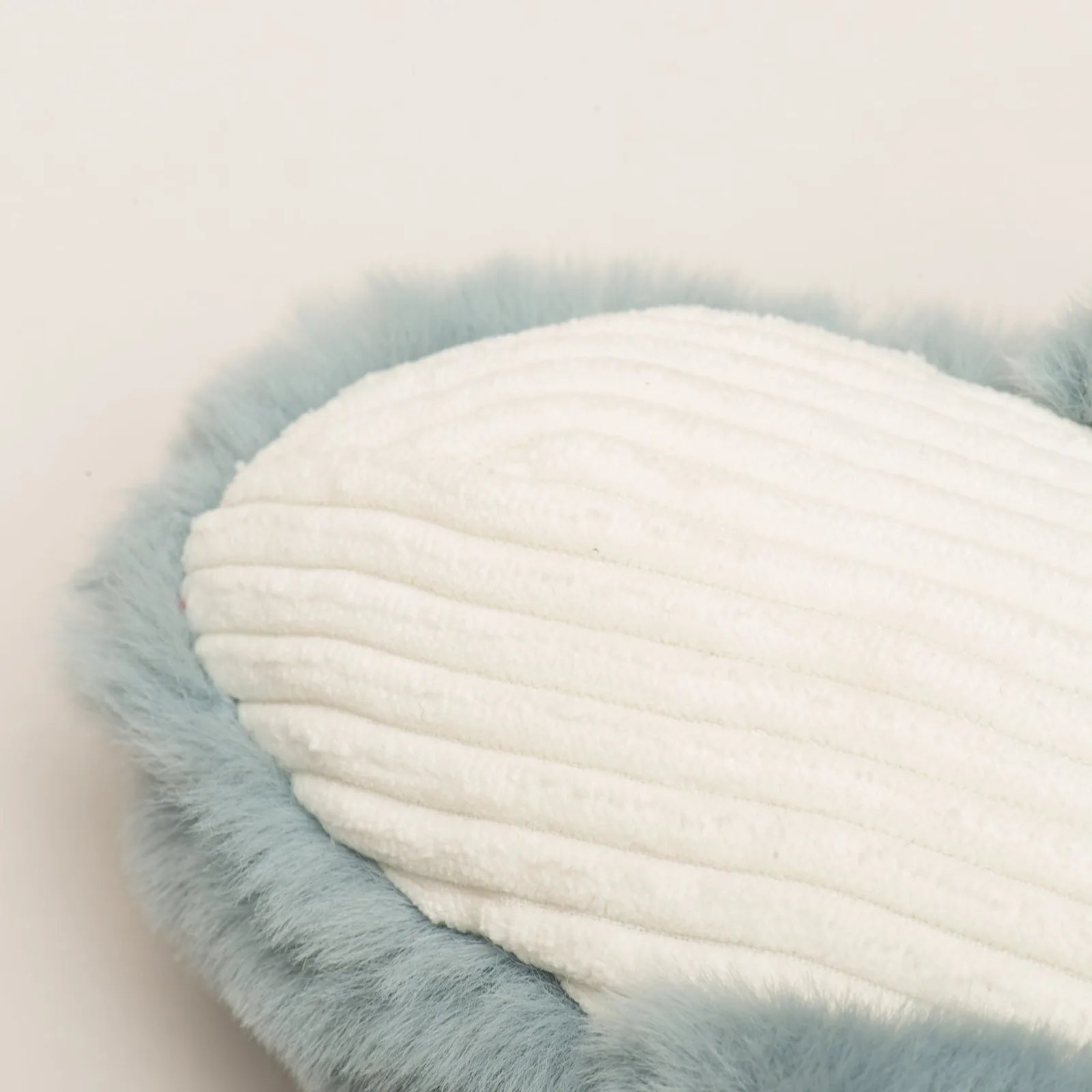 Soft plush whale toy in blue and white fibers, featuring a textured surface and a fluffy rim for dog play.