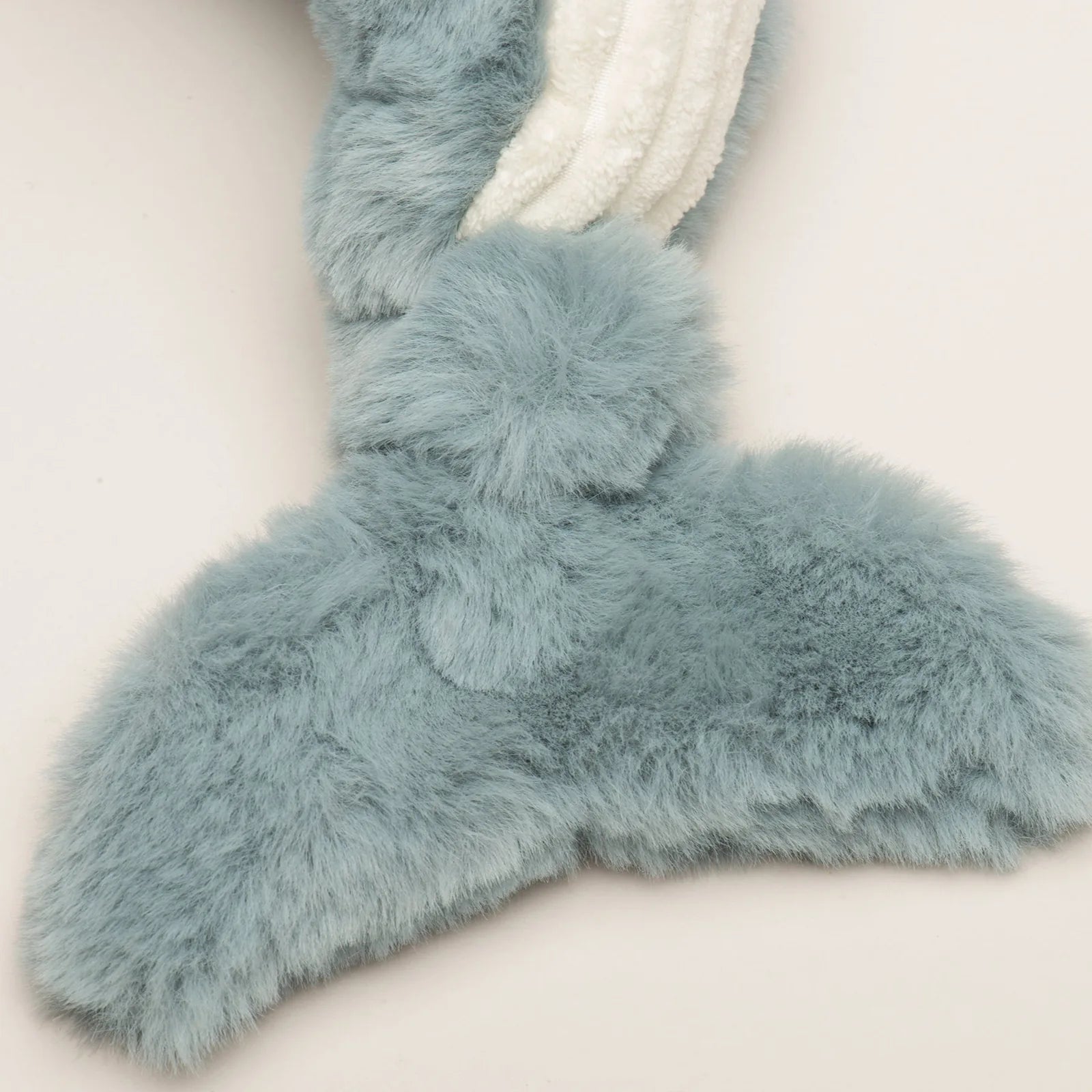 Soft, plush whale tail in light blue with a fuzzy texture, designed for interactive play and gentle chewing for dogs.