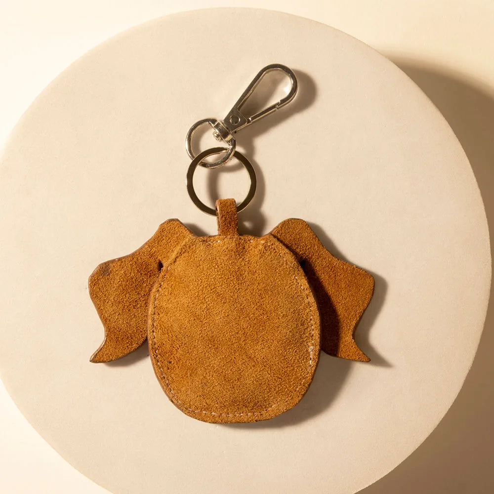 Rawhide tan leather keychain shaped like a dog with floppy ears, featuring durable zinc hardware for easy attachment.
