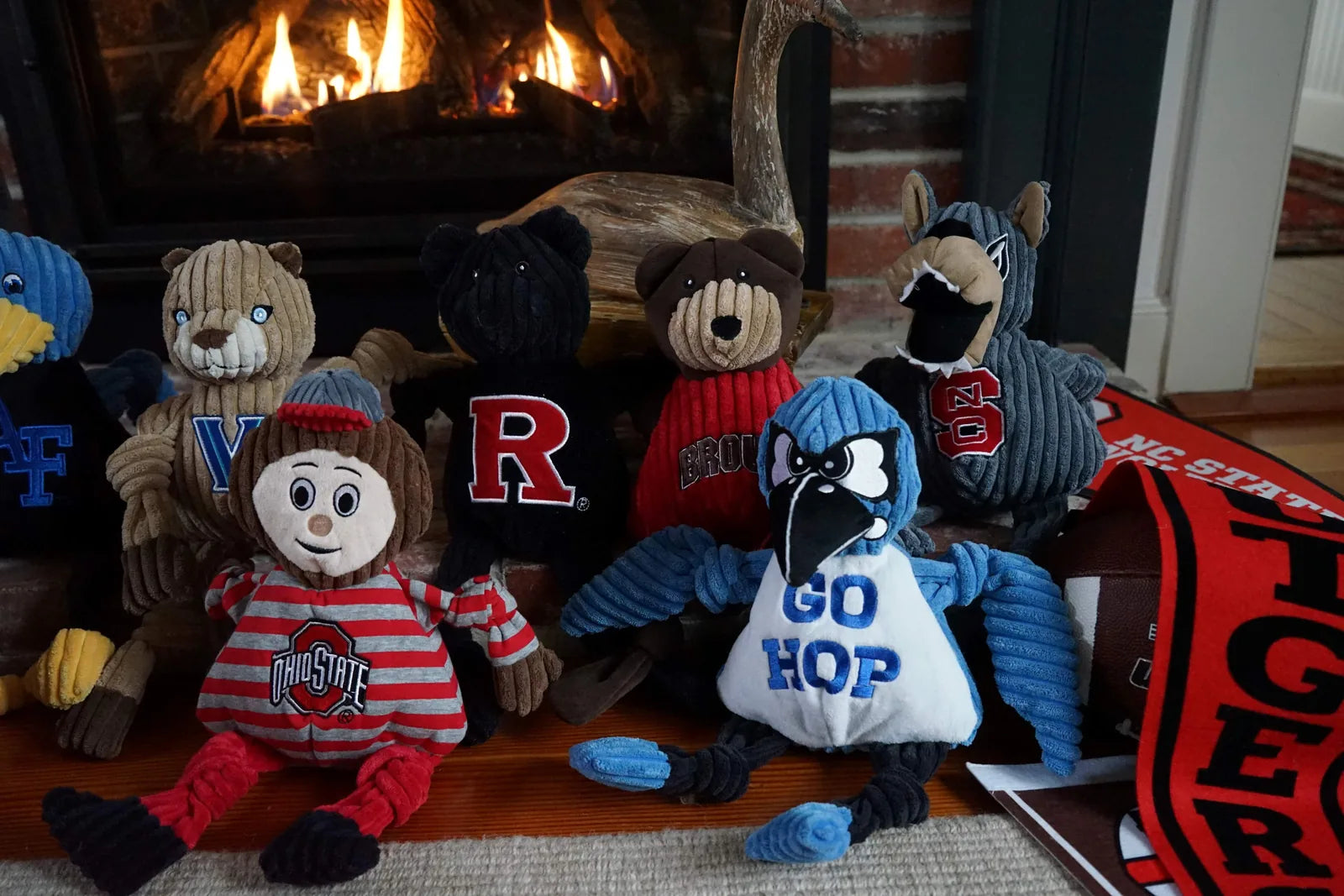 Collage of plush NCAA mascot toys, including a blue Jay, designed for dogs, with various team logos and colors.