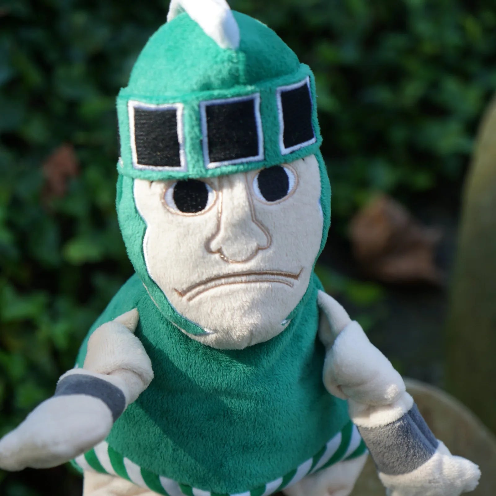 Green Sparty plush dog toy featuring a detailed face, wearing a helmet, made from soft, durable fabric.