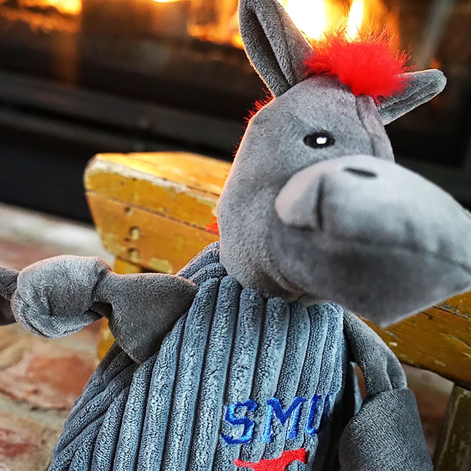 Gray plush mascot toy with knotted limbs, red tuft, and embroidered "SMU" on soft ribbed fabric, perfect for dogs.