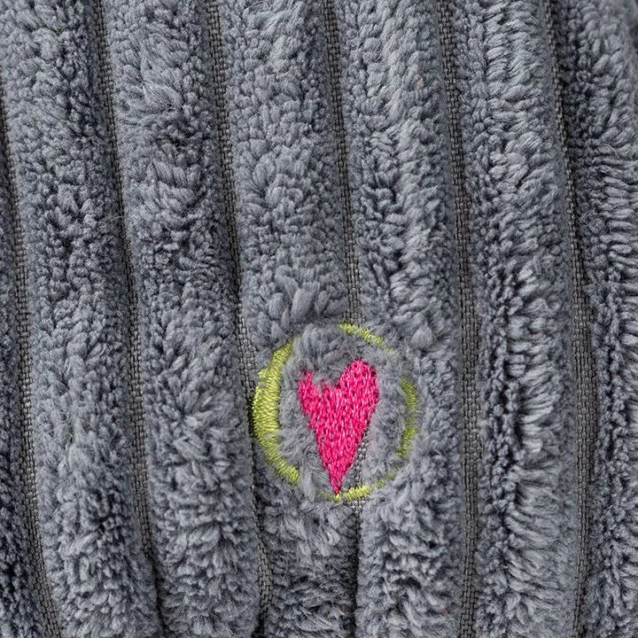 Gray plush fabric with vertical ribbing and an embroidered heart design in pink and green, part of the dog toy.