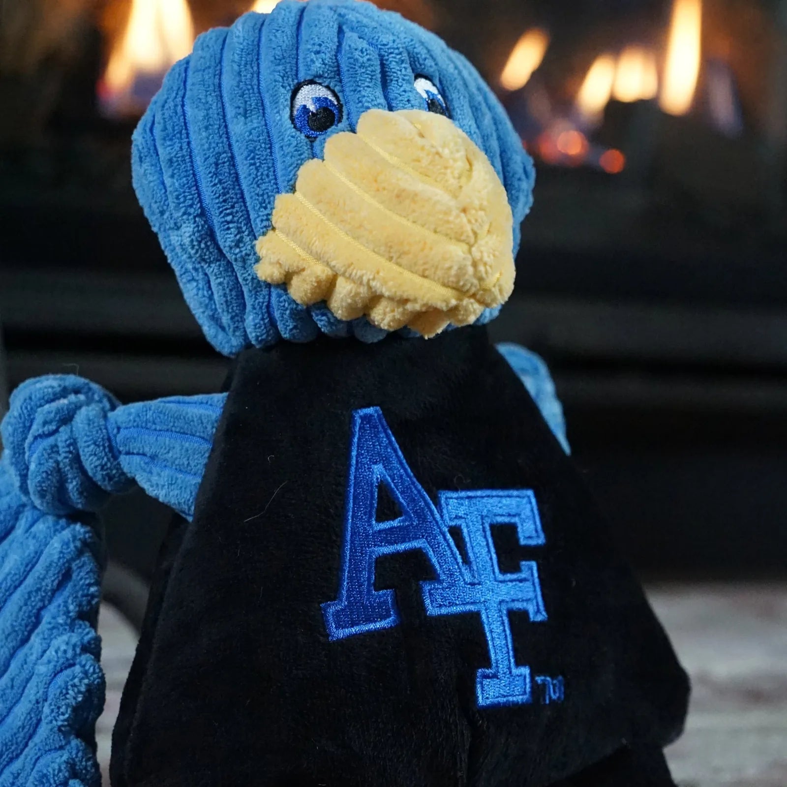 Blue plush dog toy designed as a Gyr Falcon with a yellow beak, featuring an Air Force logo on its belly.
